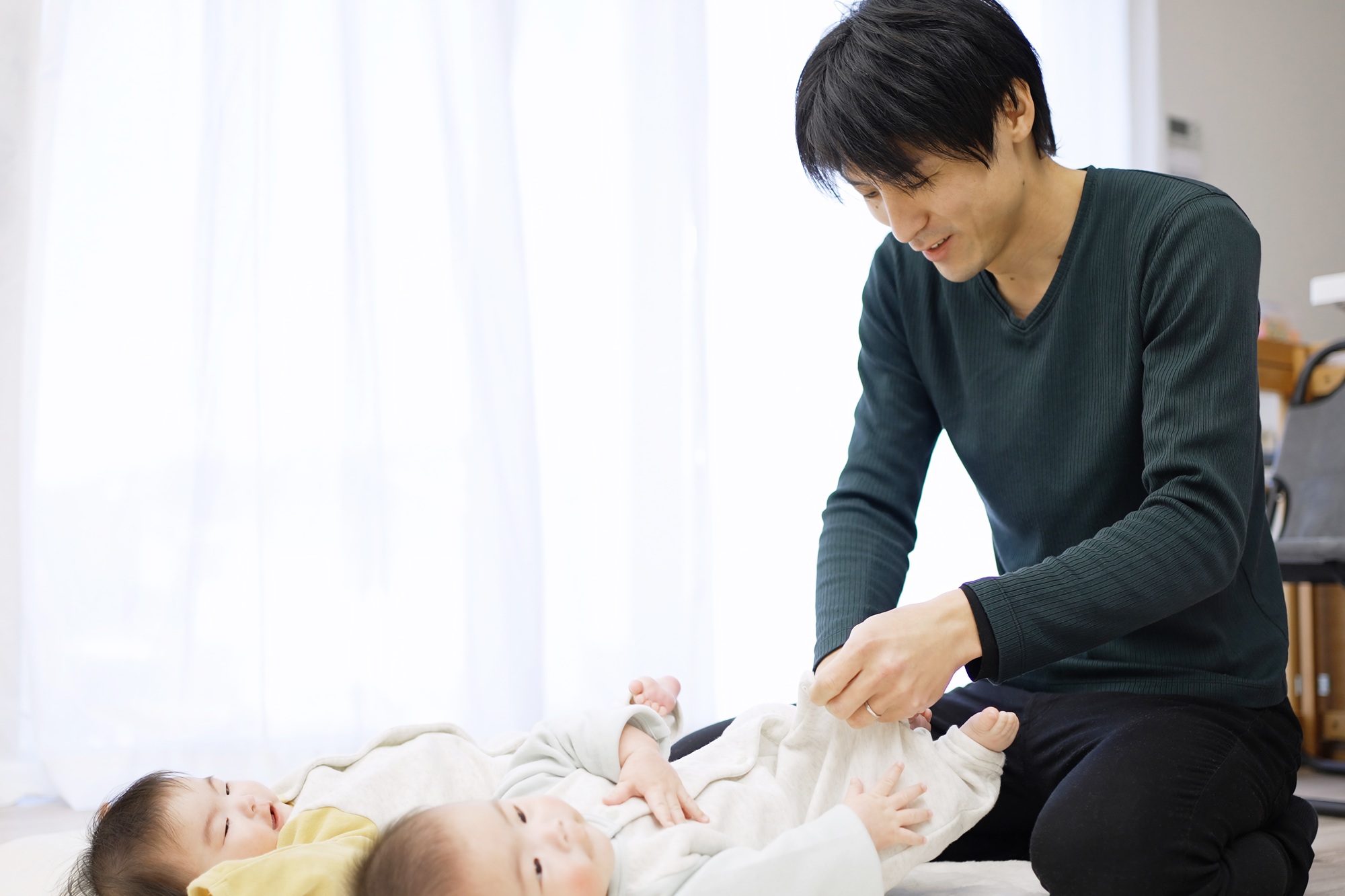 Asian dad changing baby clothes