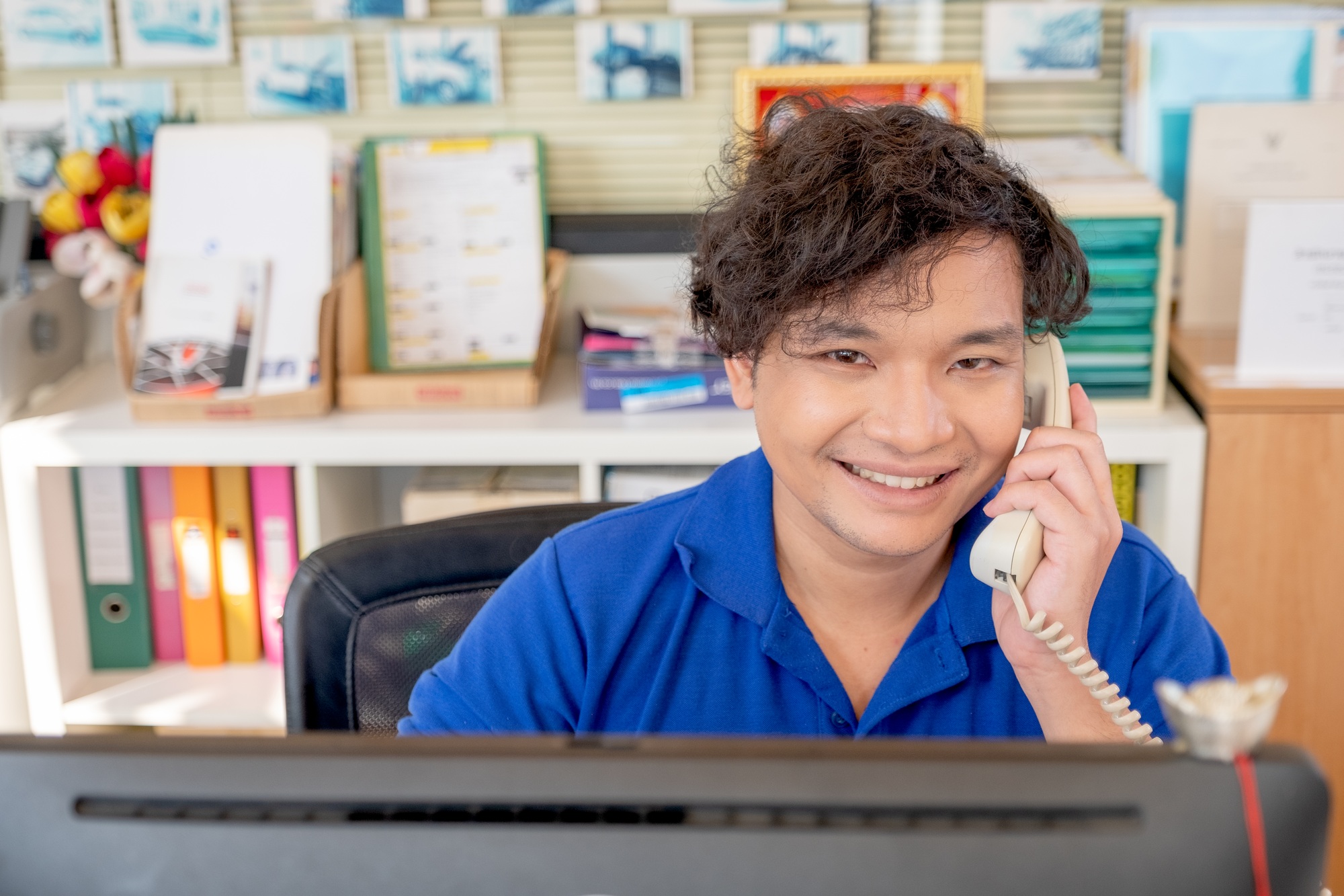 Asian staff or employee receive phone call from customer and smile also look to camera