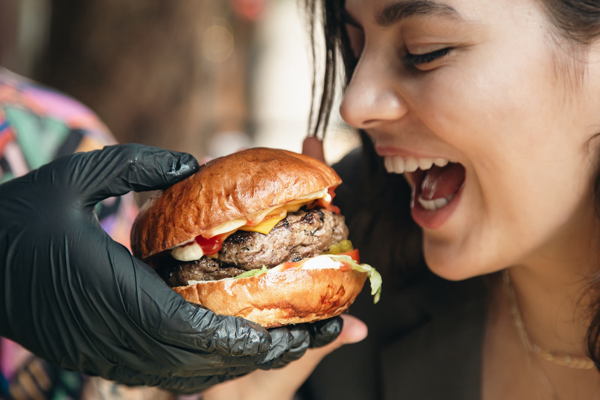 Attractive young woman eating french fries and a burger in a restaurant.