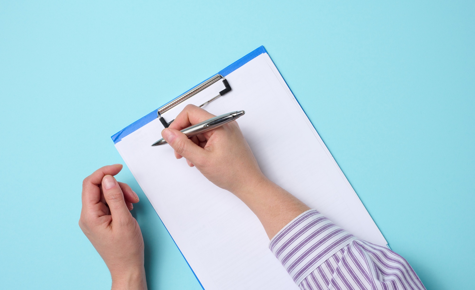 Blank white sheets and two female hands, top view. Text writing, list