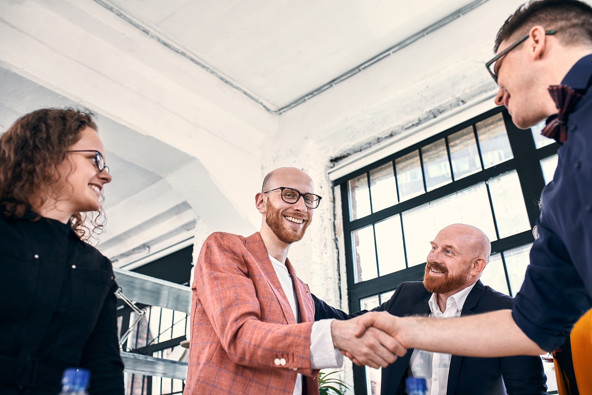 Business handshake at meeting or negotiation in the office. Partners are satisfied because signing