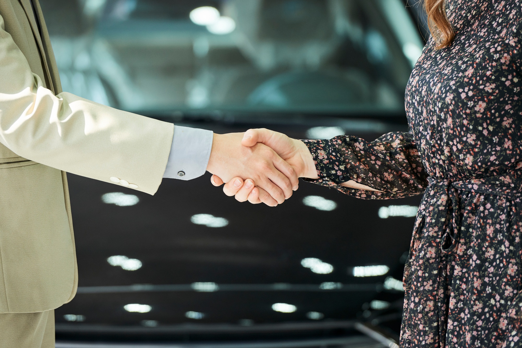 Business handshake in auto salon