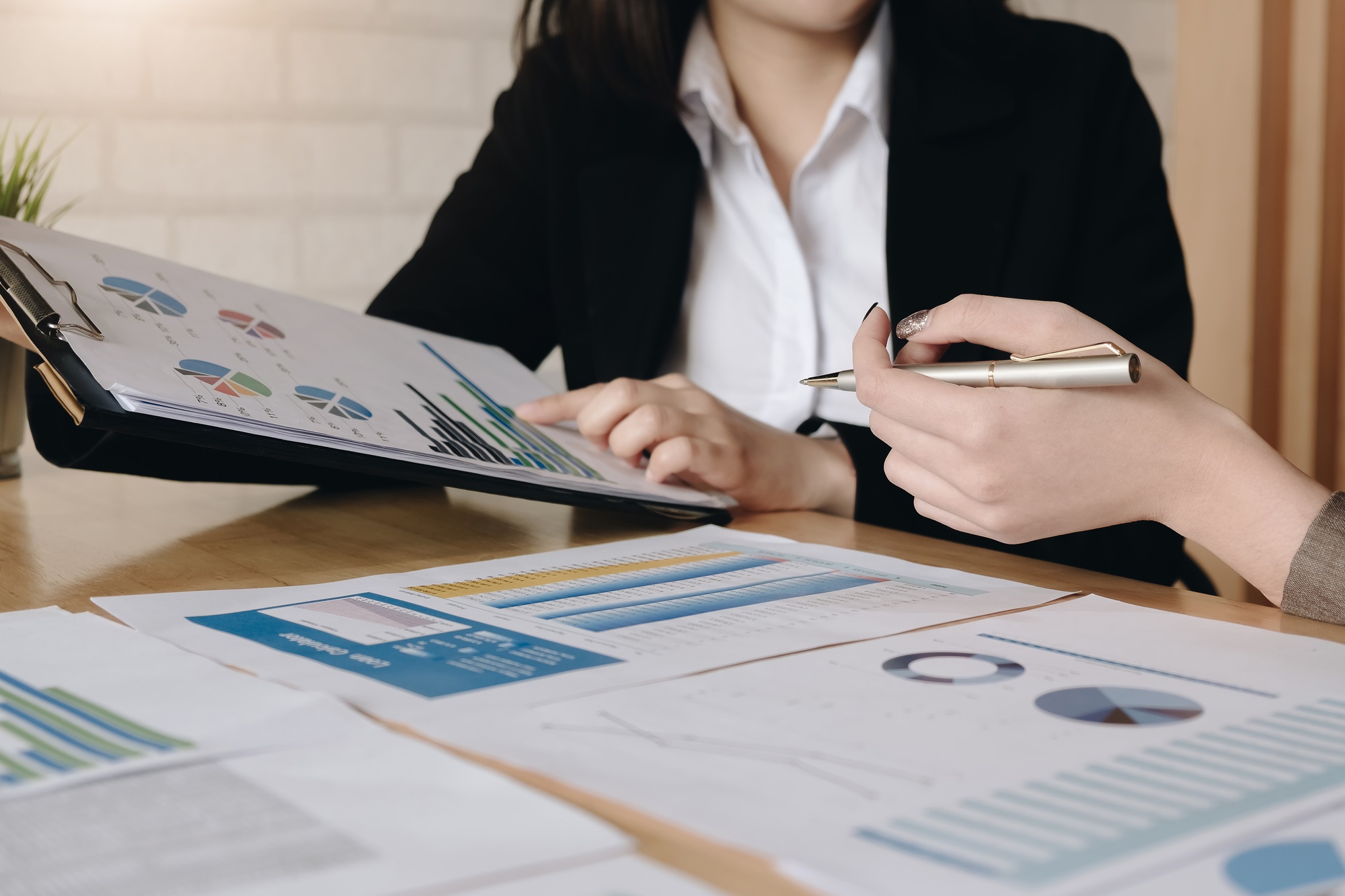 Business people using pen,tablet,notebook are planning a marketing plan to improve the quality of