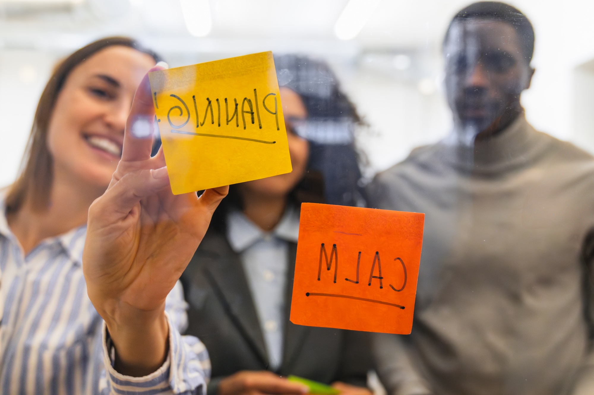 Business team brainstorming and planning using sticky notes on glass wall