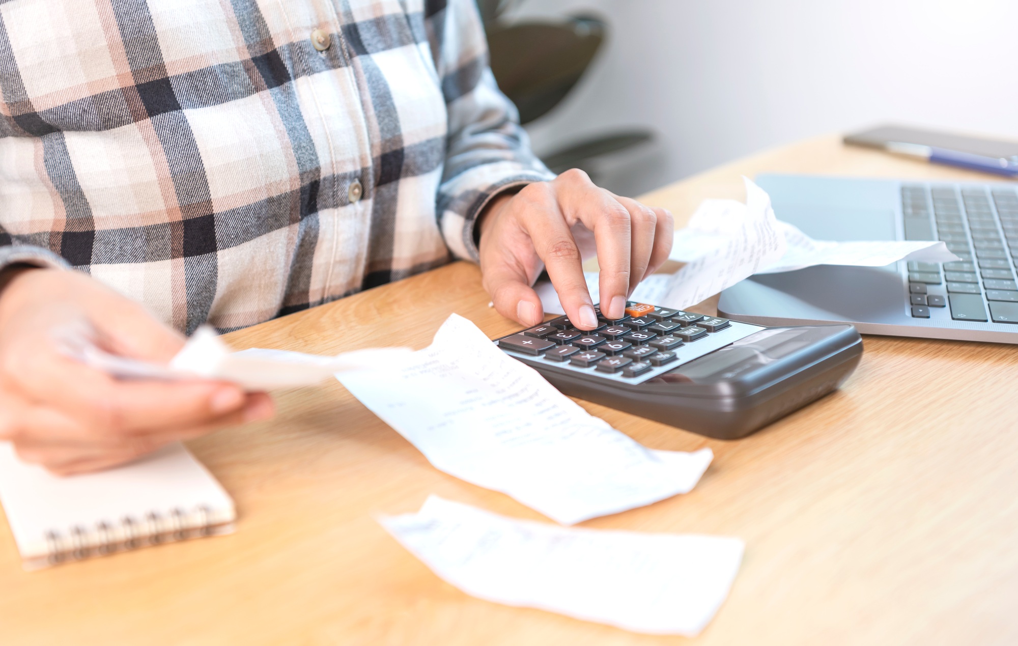 Business woman pressing the calculator calculate the various costs