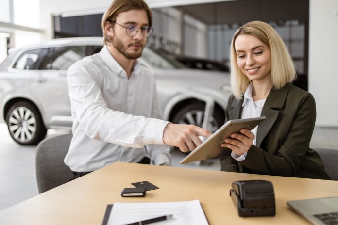 Businessman choosing auto, buying new automobile in car showroom.