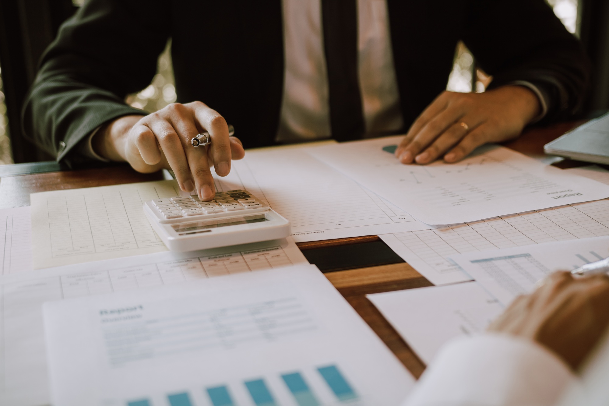 Businessmen are calculating the cost of the company's sales and analyzing the graph in the office.