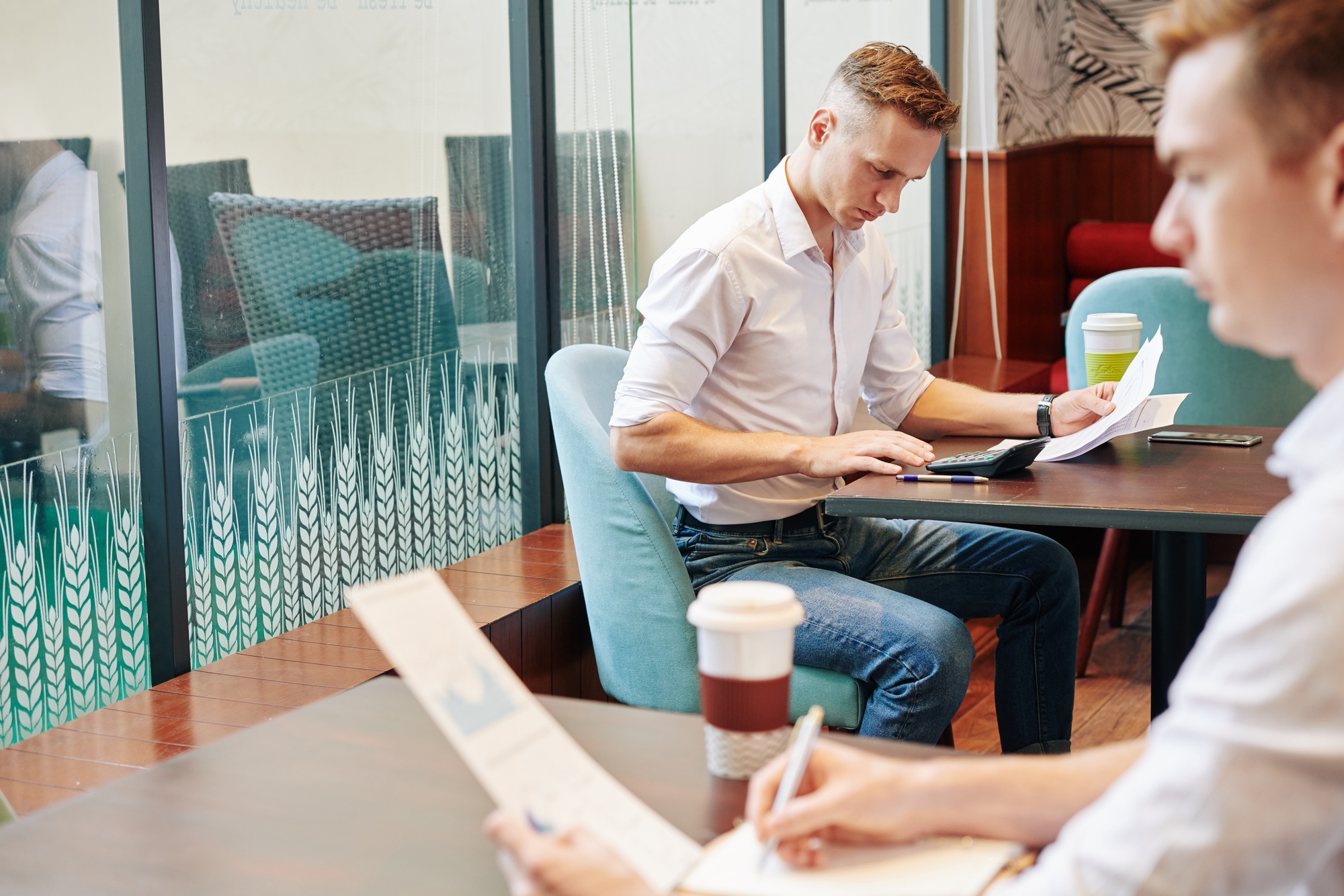 Businessmen working with documents in local cafe