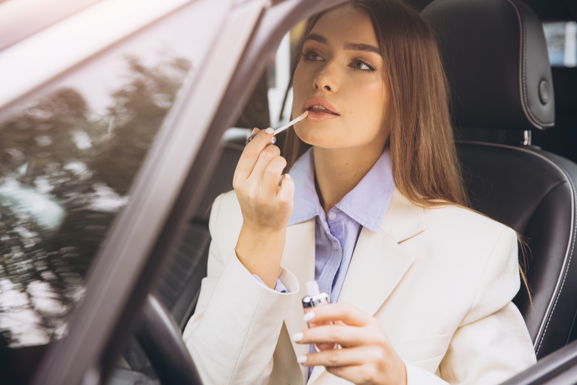 Businesswoman Applying Lip Gloss Inside Her Car