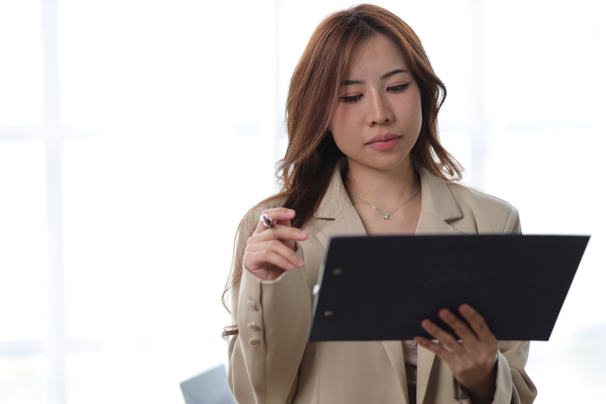 Businesswoman reading documents and analyzing work schedule.