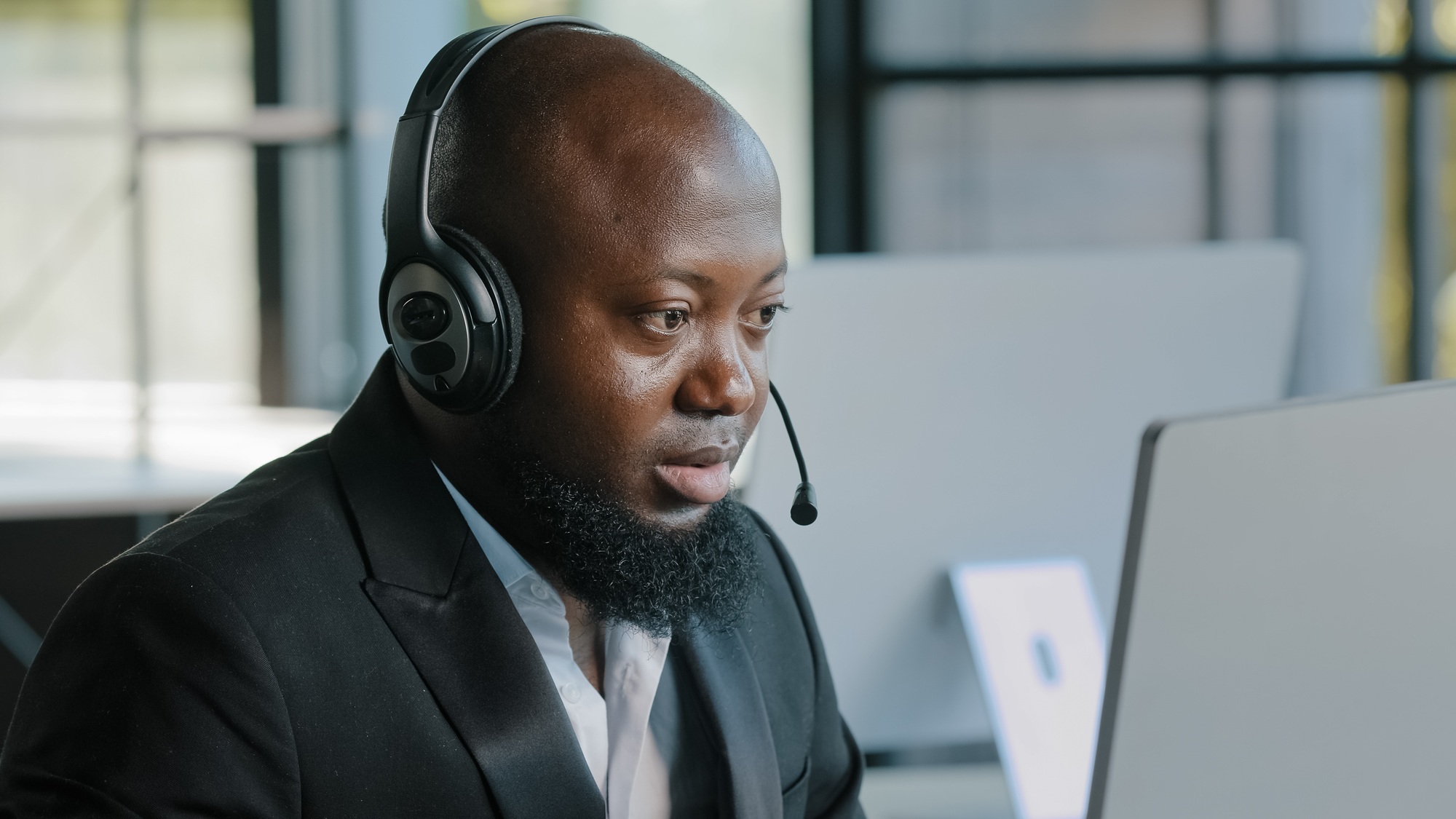 Busy adult manager marketing specialist software engineer wearing headphones working on laptop using
