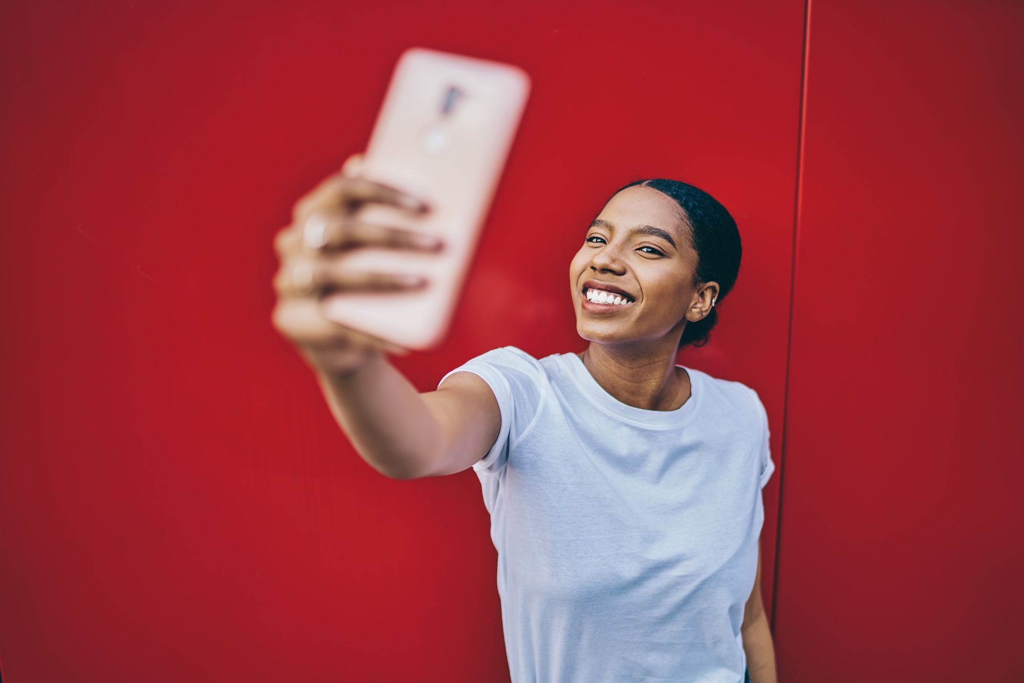 Cheerful African American female shooting influence vlog during mobile networking