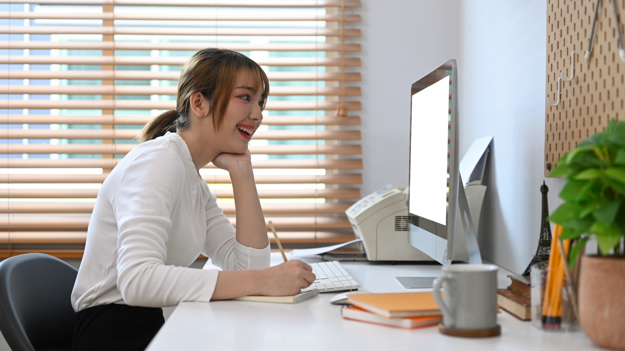 Cheerful young woman freelancer working online from home, checking business email on computer.