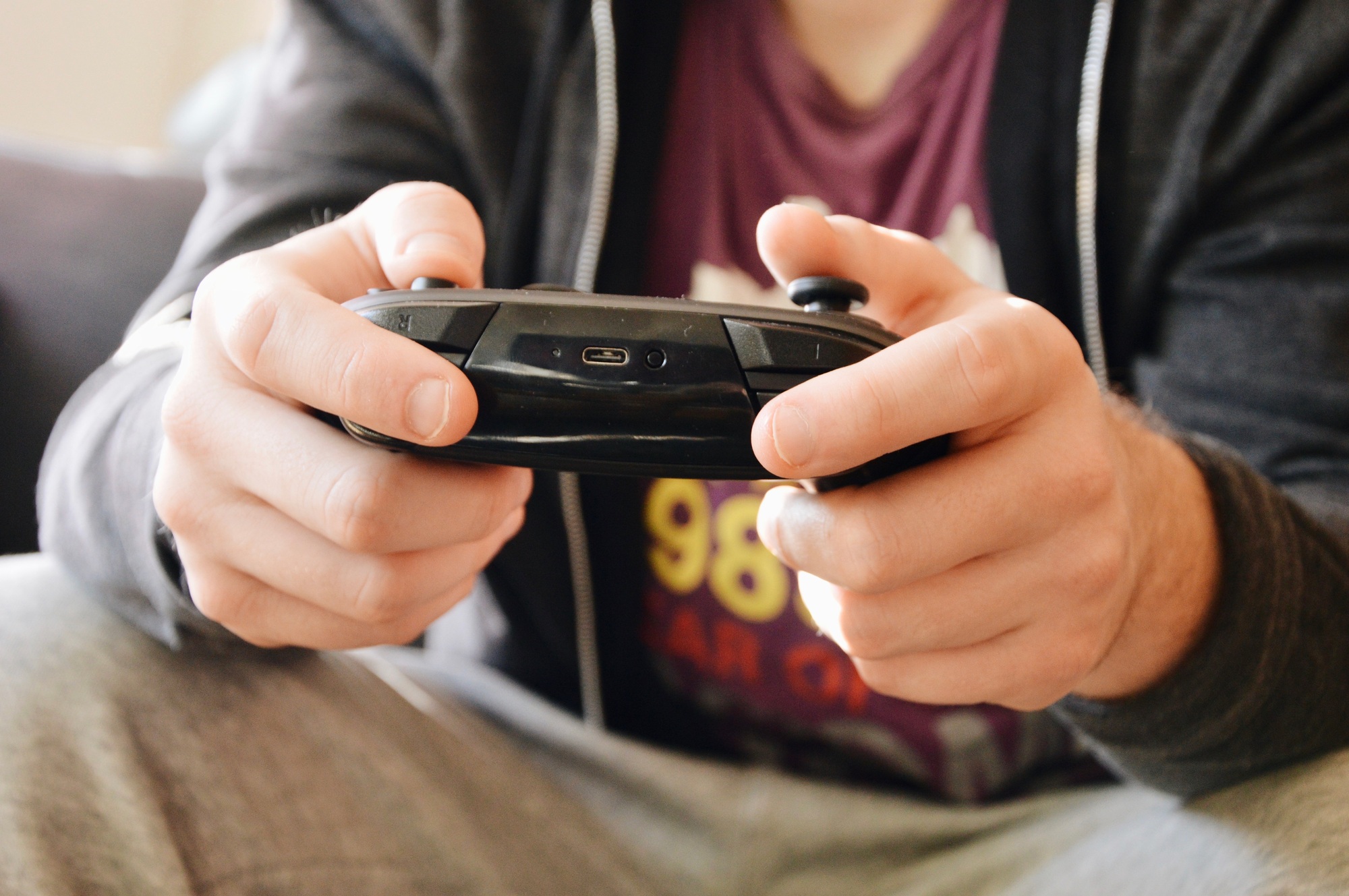 Close-up of young man playing tv games in relaxed clothes
