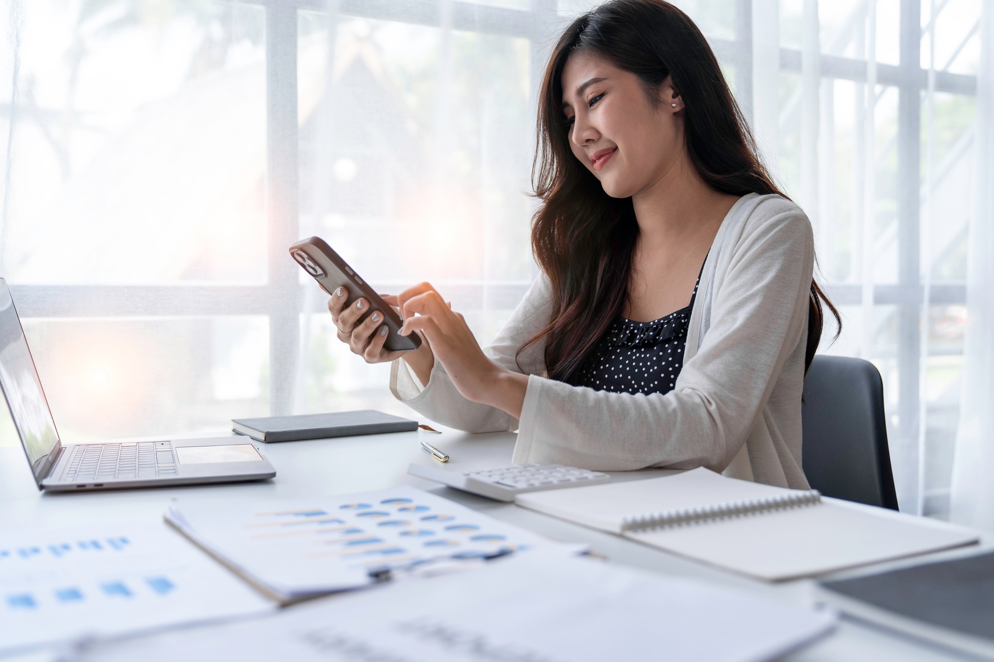 Closeup image of a businesswoman holding and using mobile phone