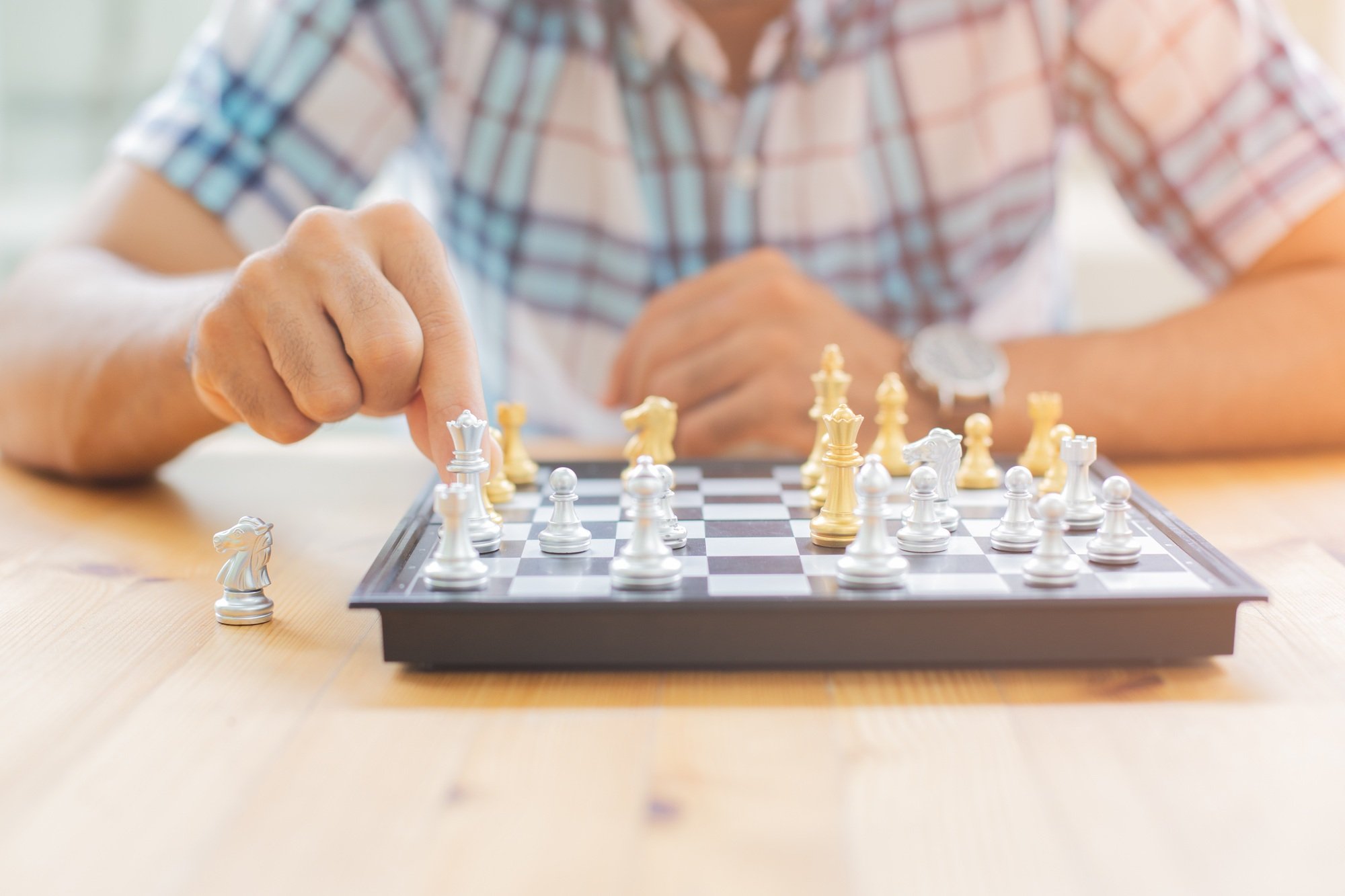Closeup image of a leader moving and playing chessboard game.