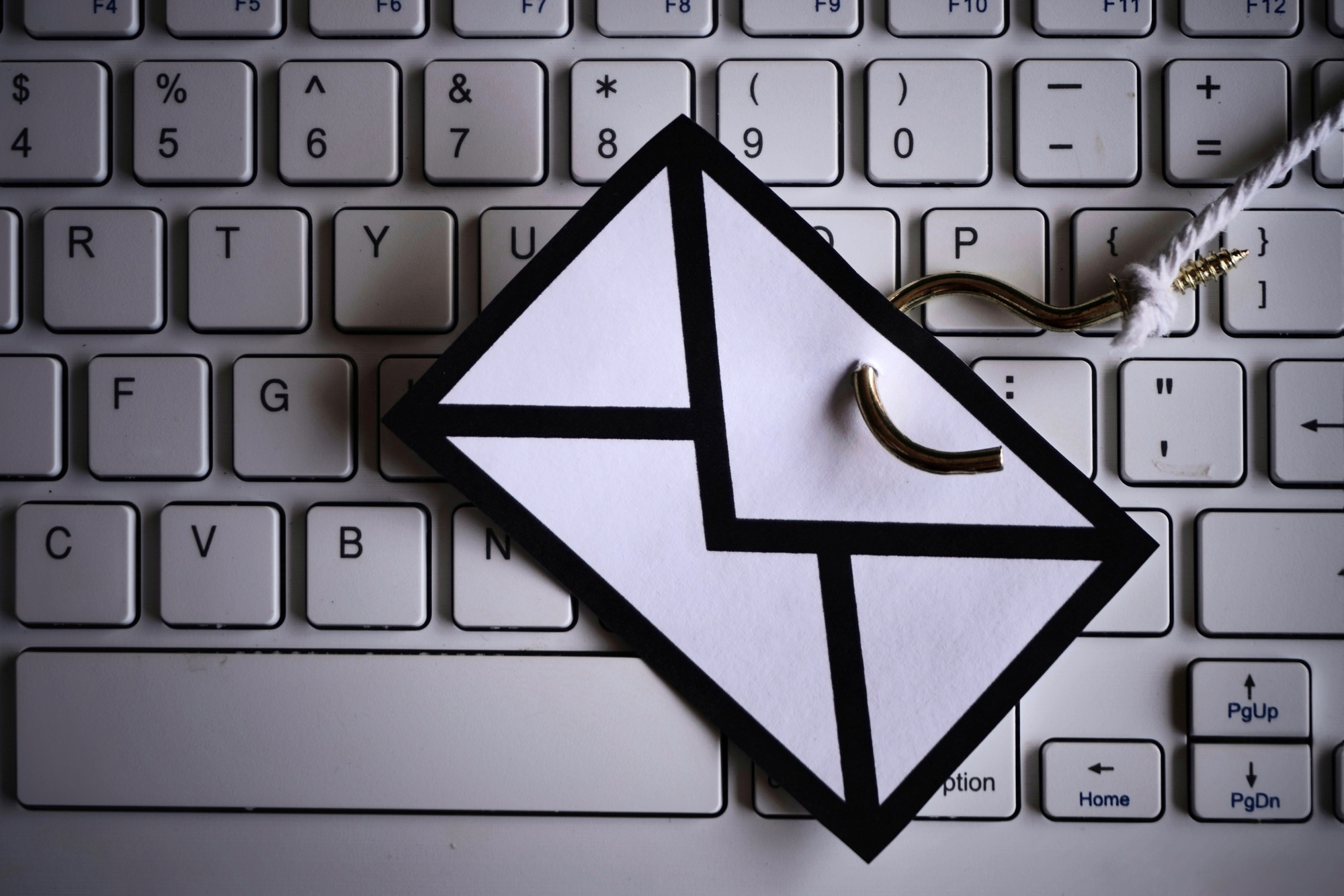 Closeup image of mail with hook on top of keyboard.