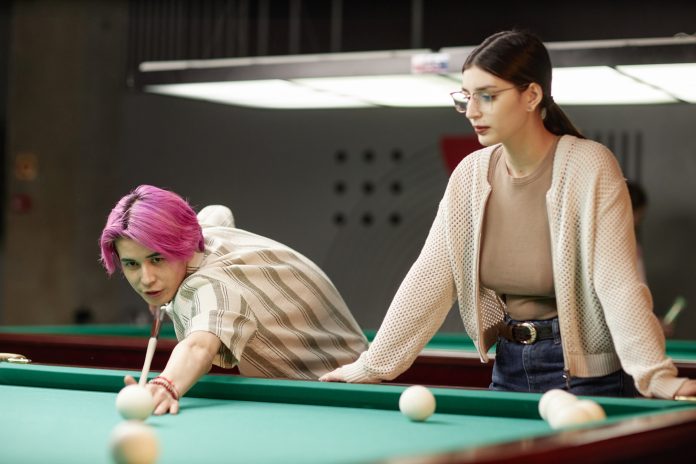 Concentrating While Playing Billiards Game with Friend