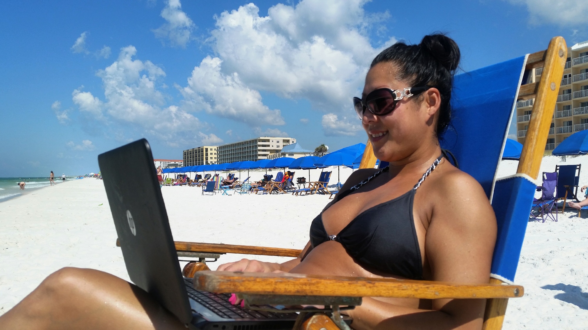 Confident women of Asian representation on vacation working on laptop on marketing strategy.