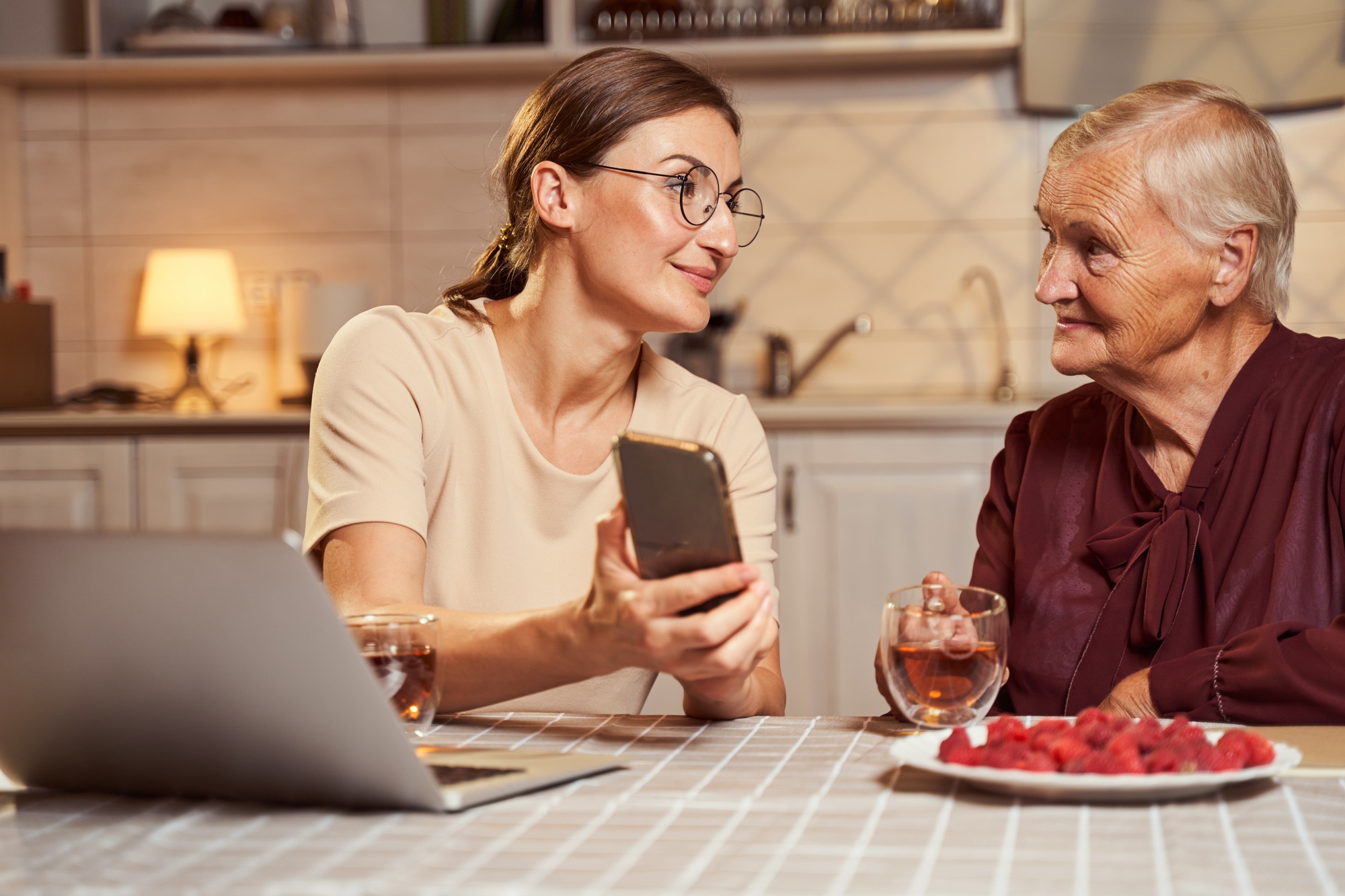 Content adult sharing photos with senior woman