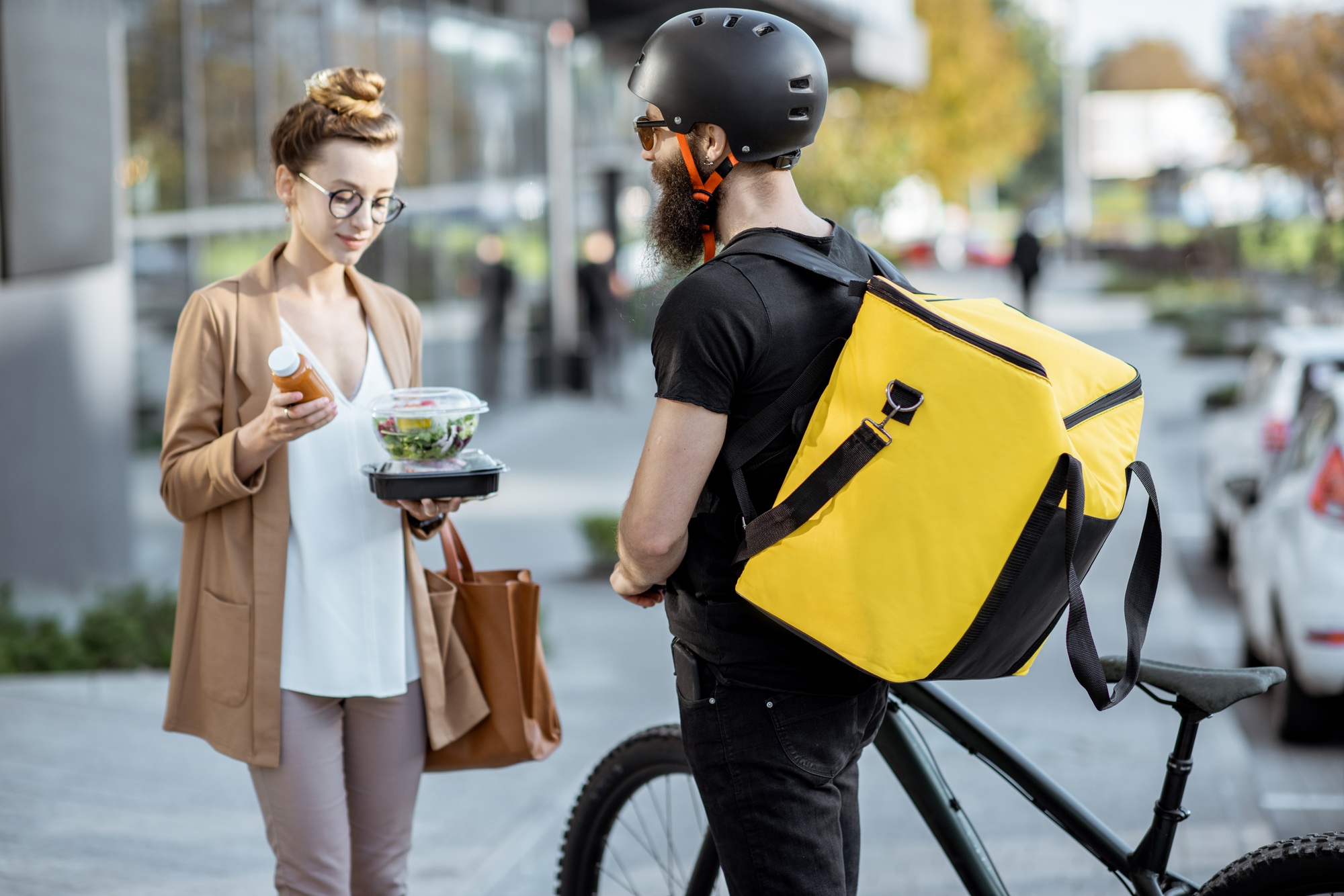 Courier delivering food to a business woman outdoors