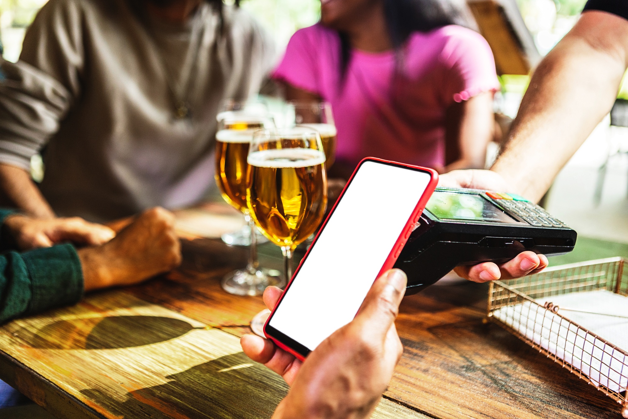 Customer using mobile phone to pay the bill in a bar