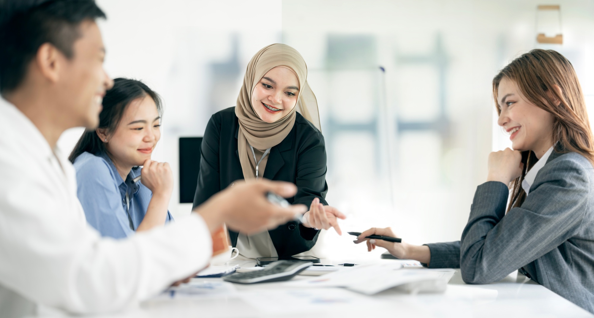 diverse coworkers working together in boardroom, brainstorming, discussing business strategy.