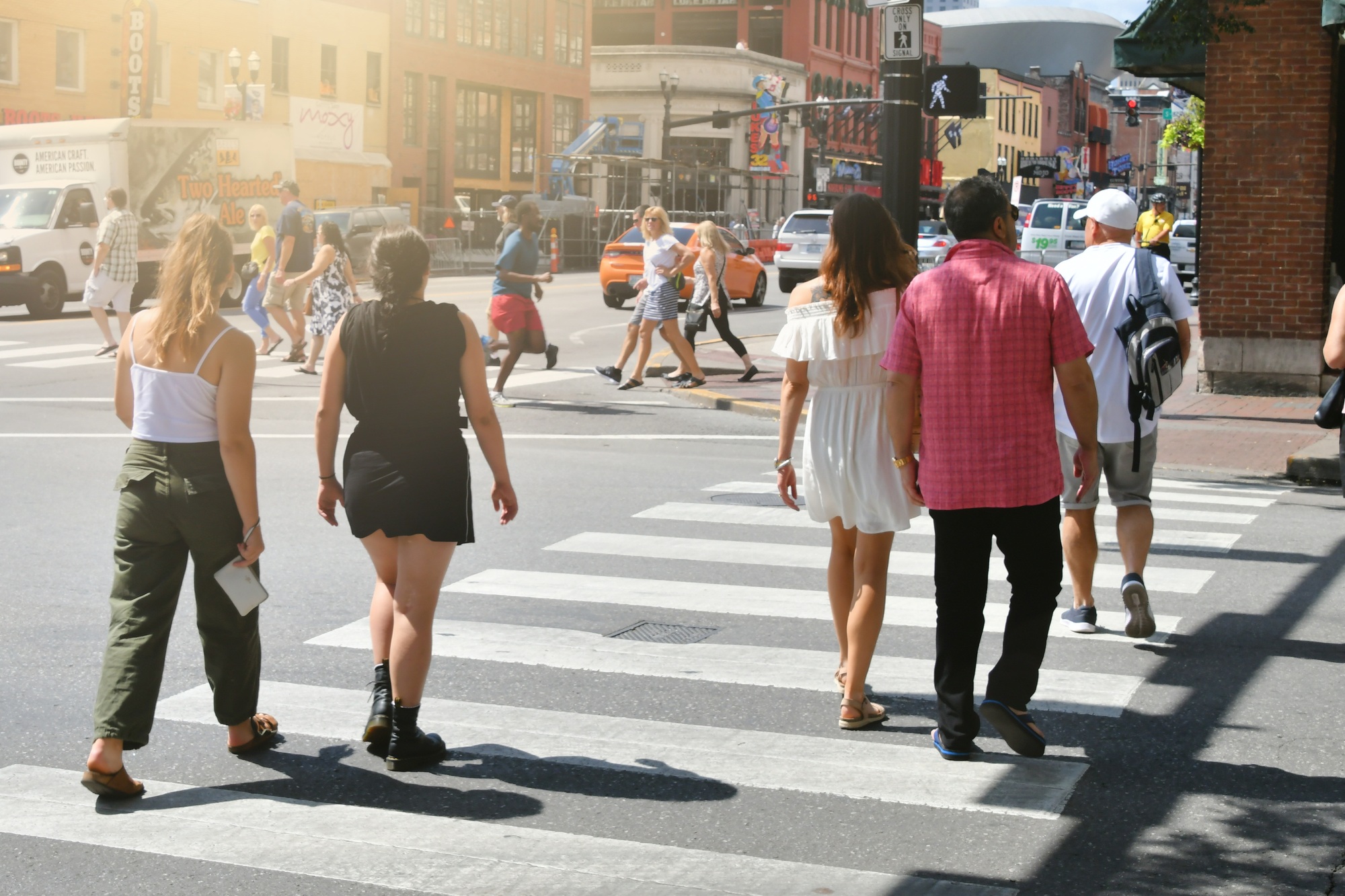 Downtown Nashville TN with traffic and Lower Broadway in the background and people crossing street