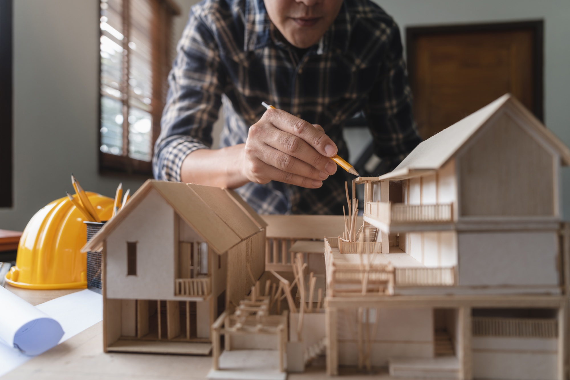 Engineer architect designer freelance work on start-up project with home model, construction plan
