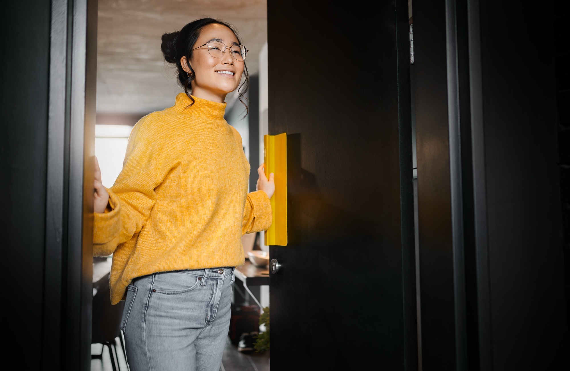 Entrance, creative and Asian woman opening a door to an office at a graphic design startup company.