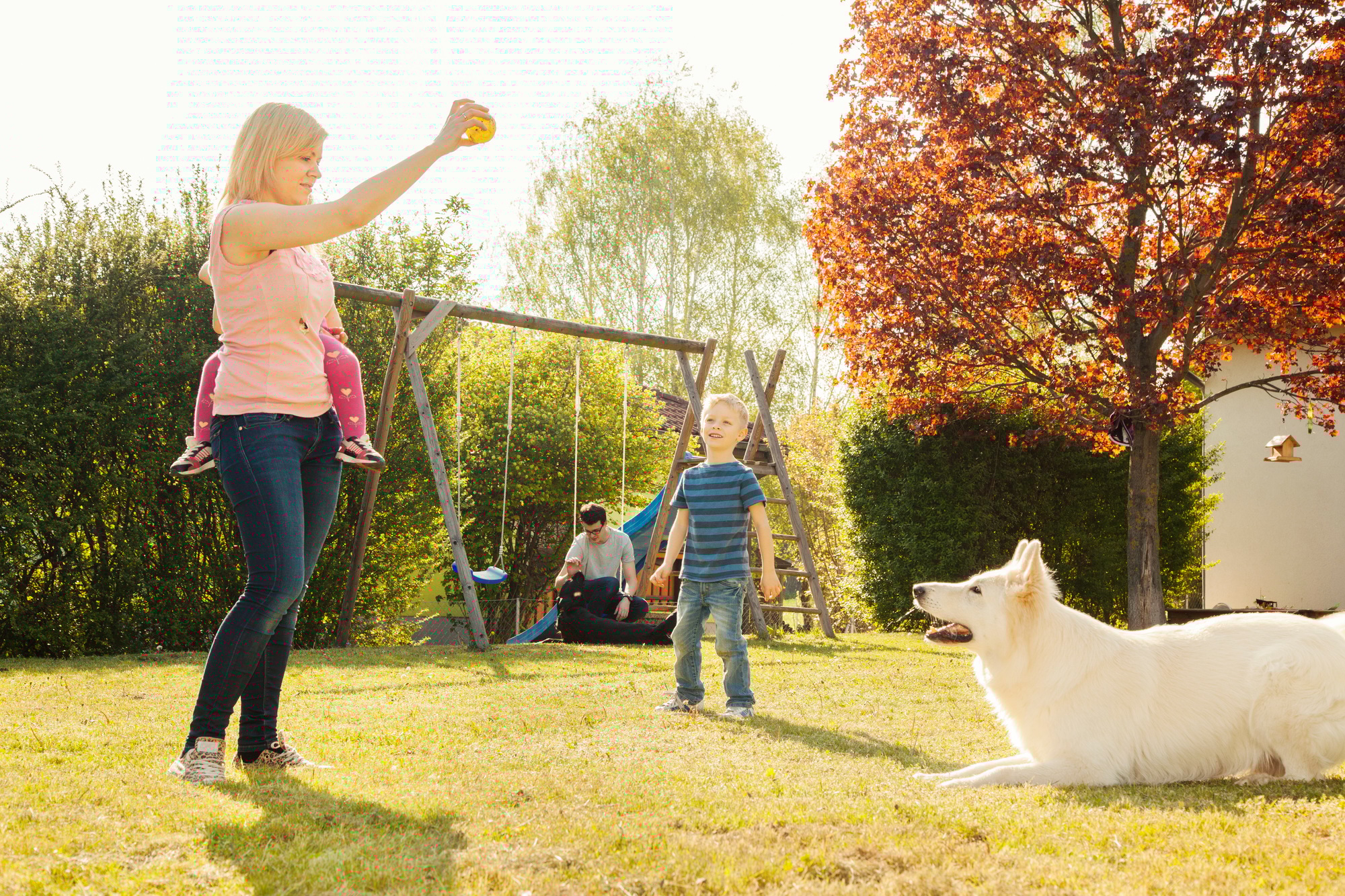 Family in garden training dog
