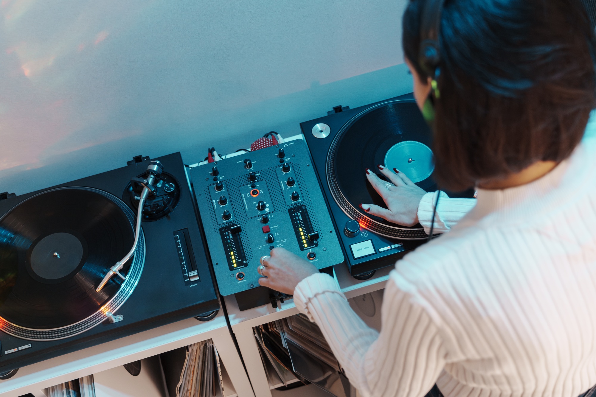 Female dj mixing tracks on professional turntable at event