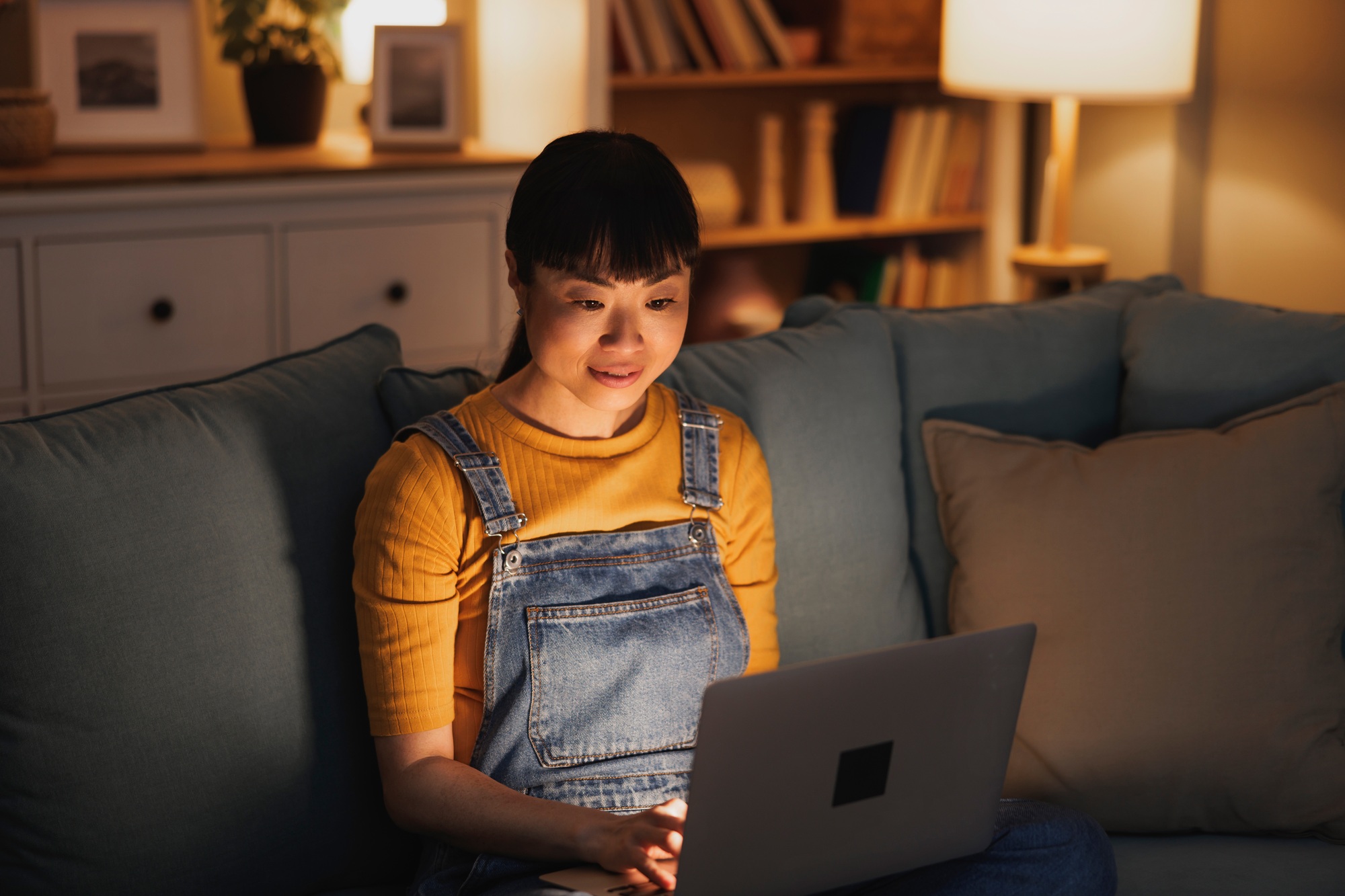 Female freelancer working from home late at night using laptop computer