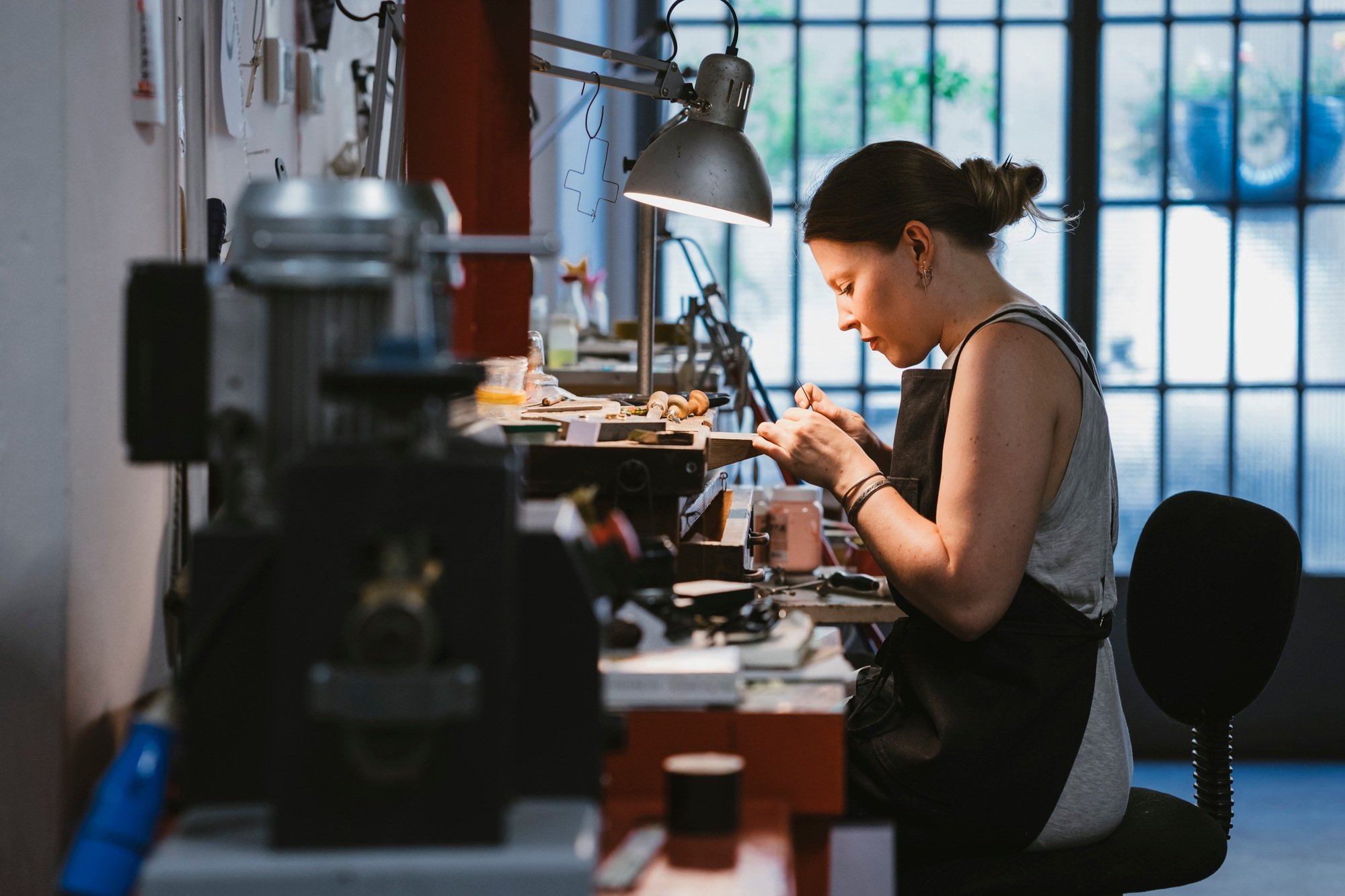 Female jeweller at work in jewellery workshop
