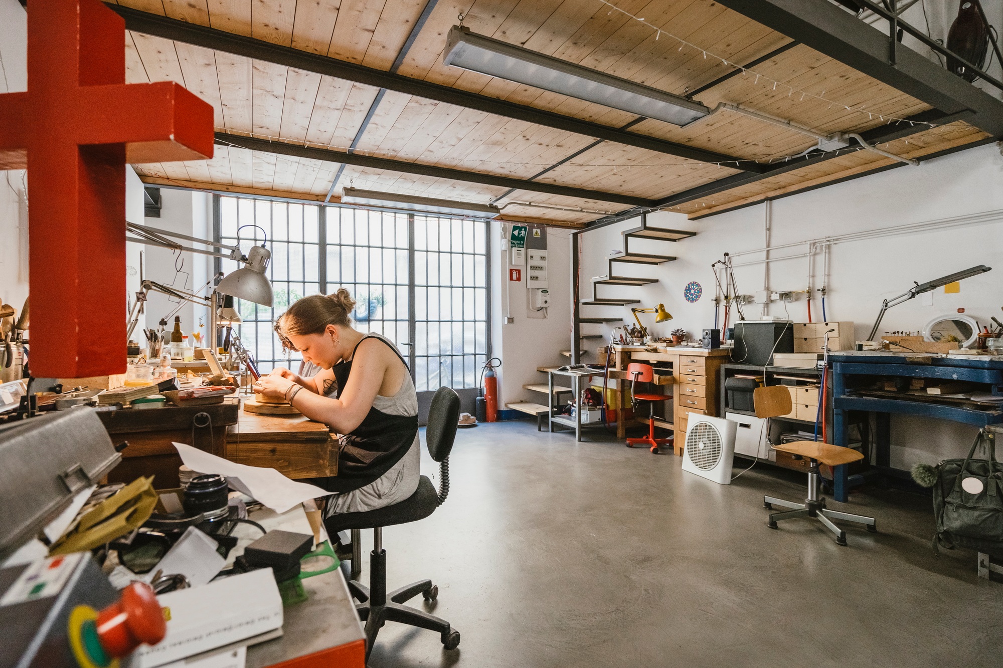 Female jeweller working at jewellery workshop workbench