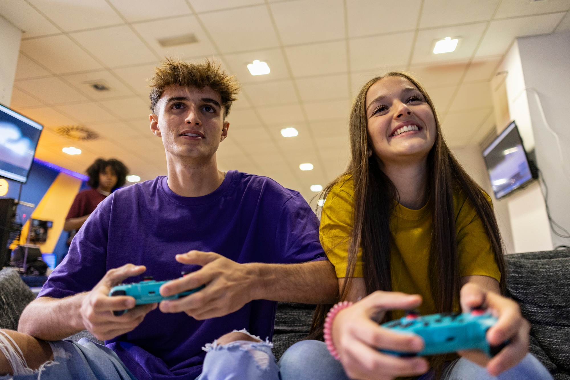 Gamers playing video games with wireless controllers in gaming room