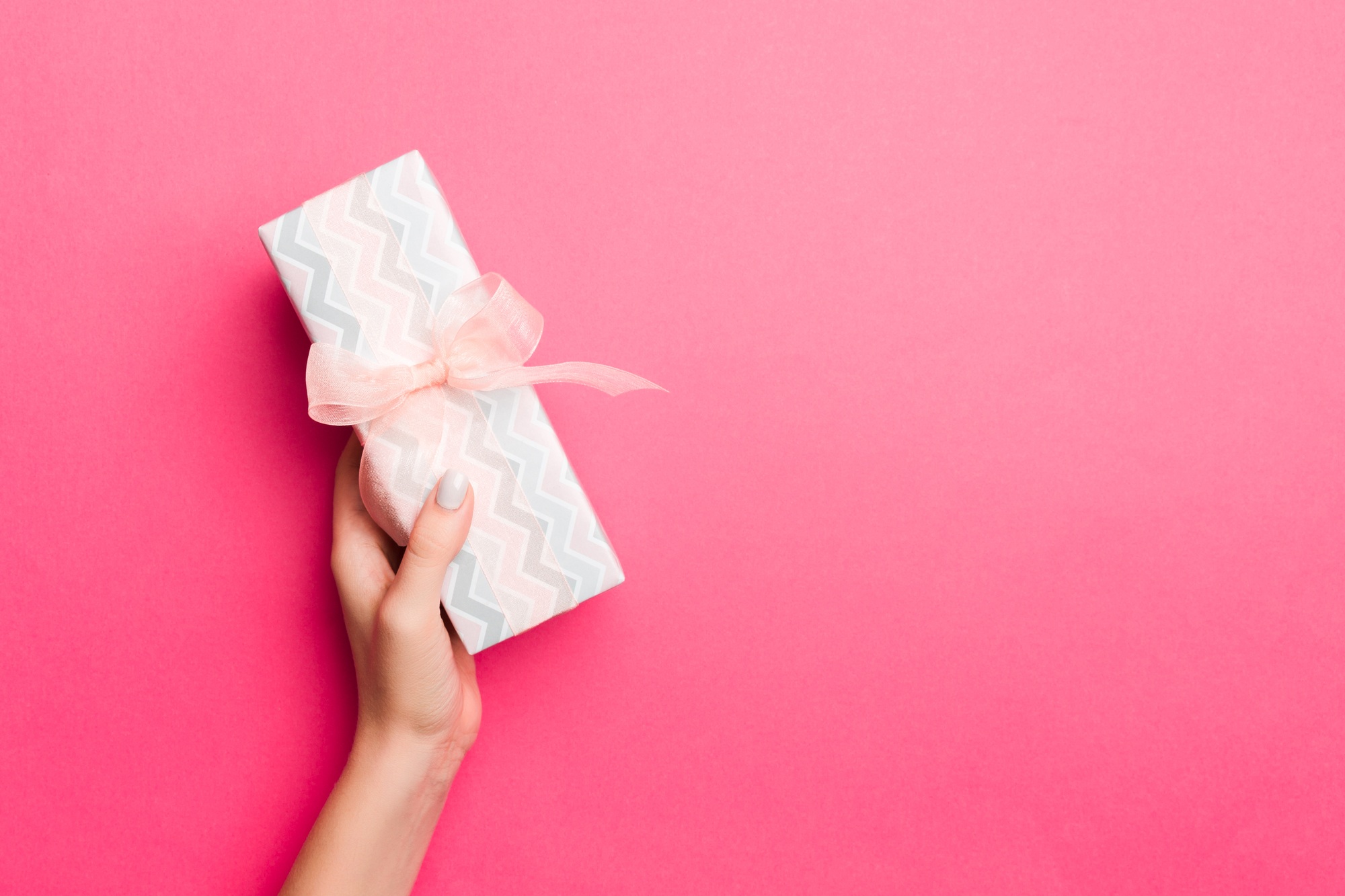 Girl Hands holding craft paper gift box with as a present for Christmas or other holiday