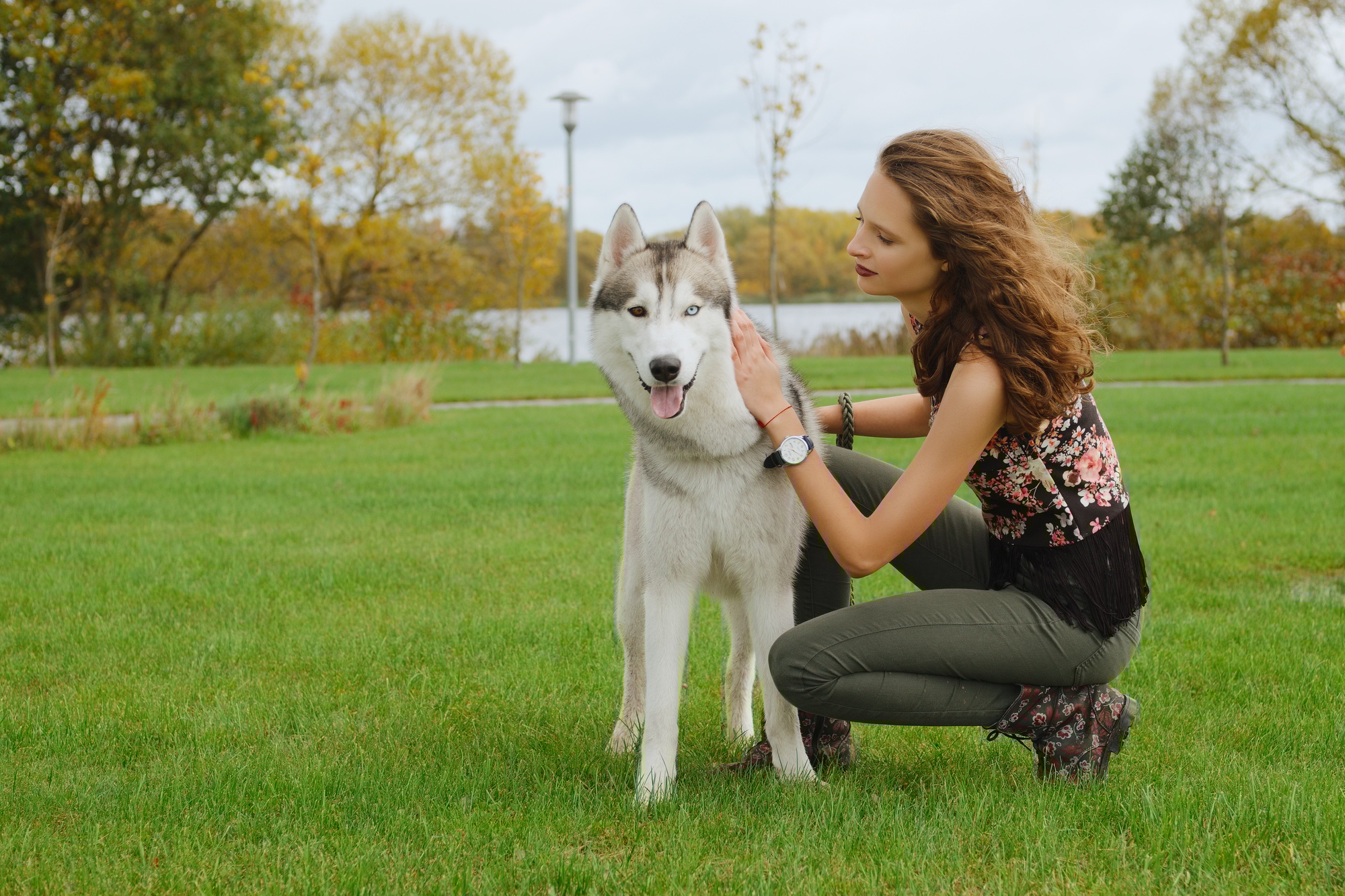 Girl playing with dog in city park. Training the dog.