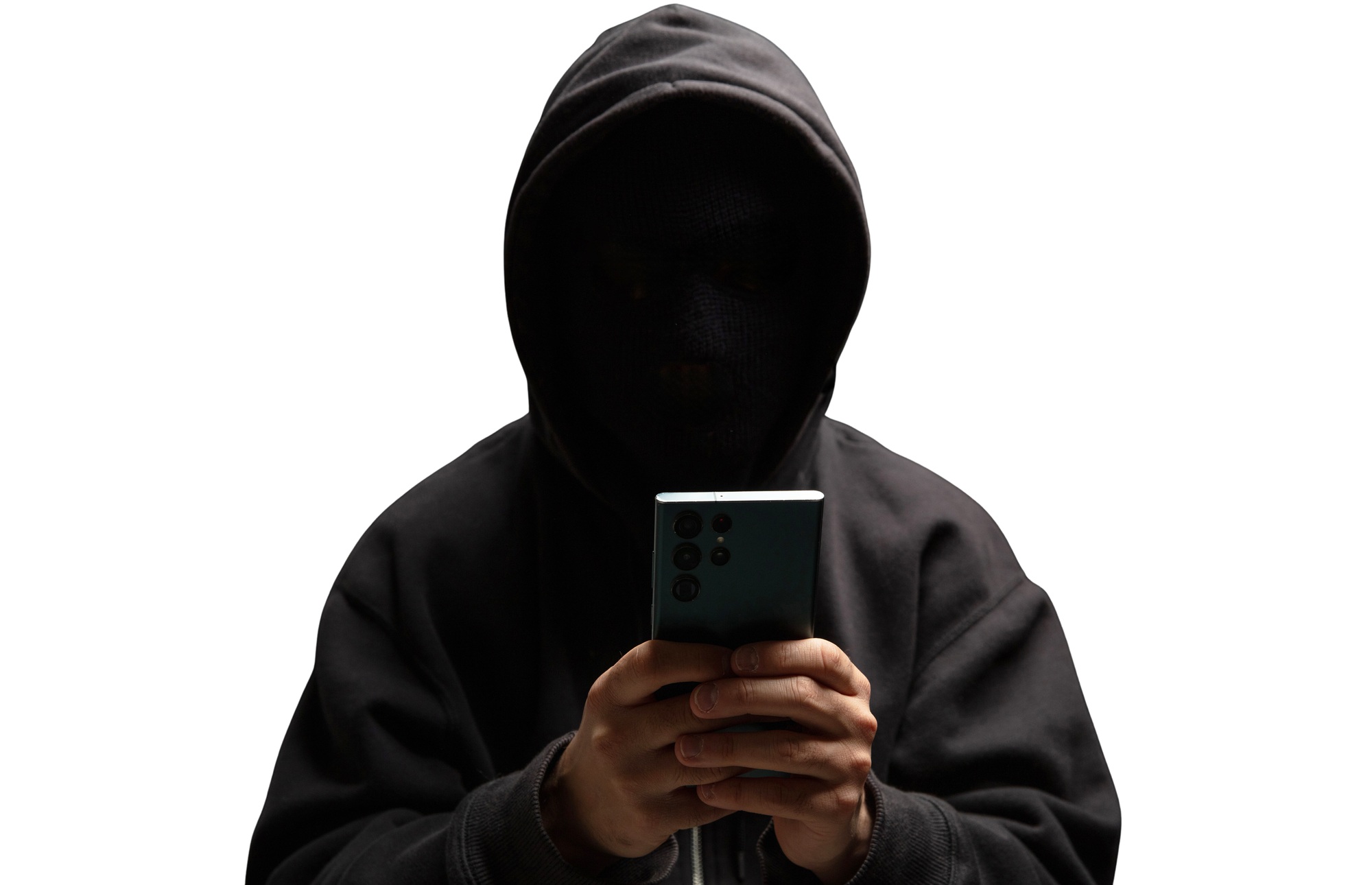 Hacker in hood holding a cellphone isolated on white. Scam cyber crime