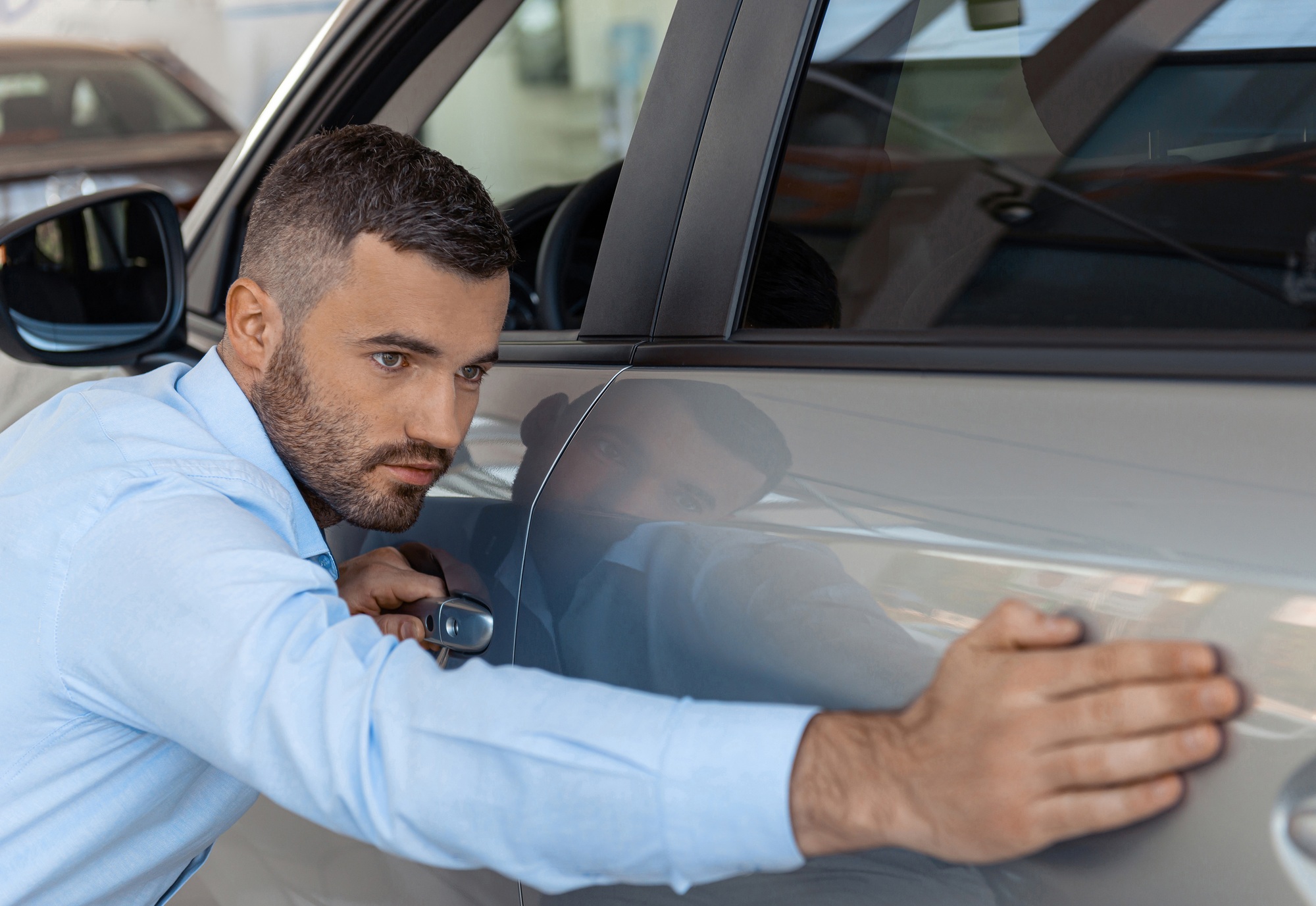 Handsome businessman touching and checking new car. Concept for car rental