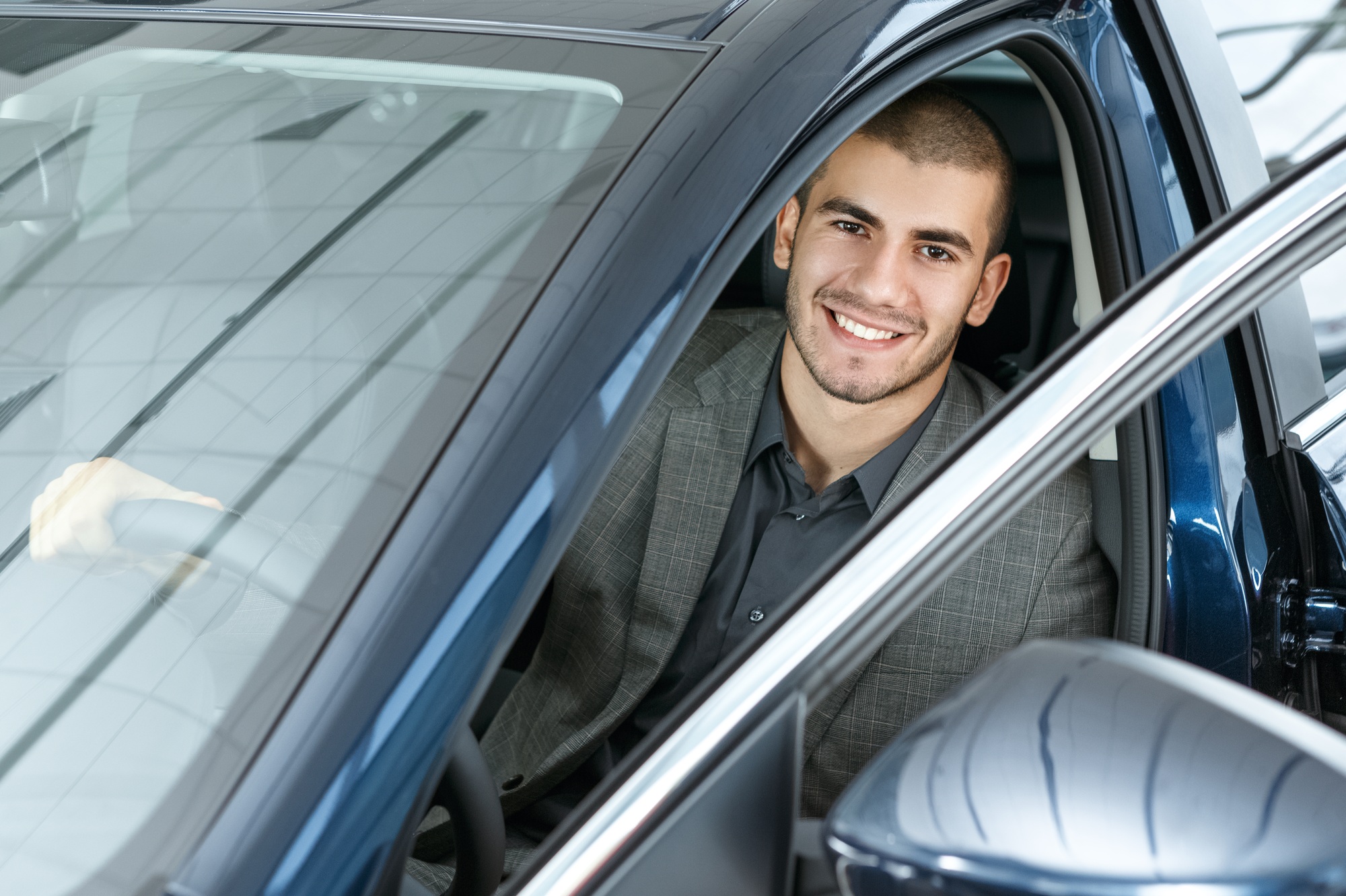 Happy male buyer enjoying new car acquisition