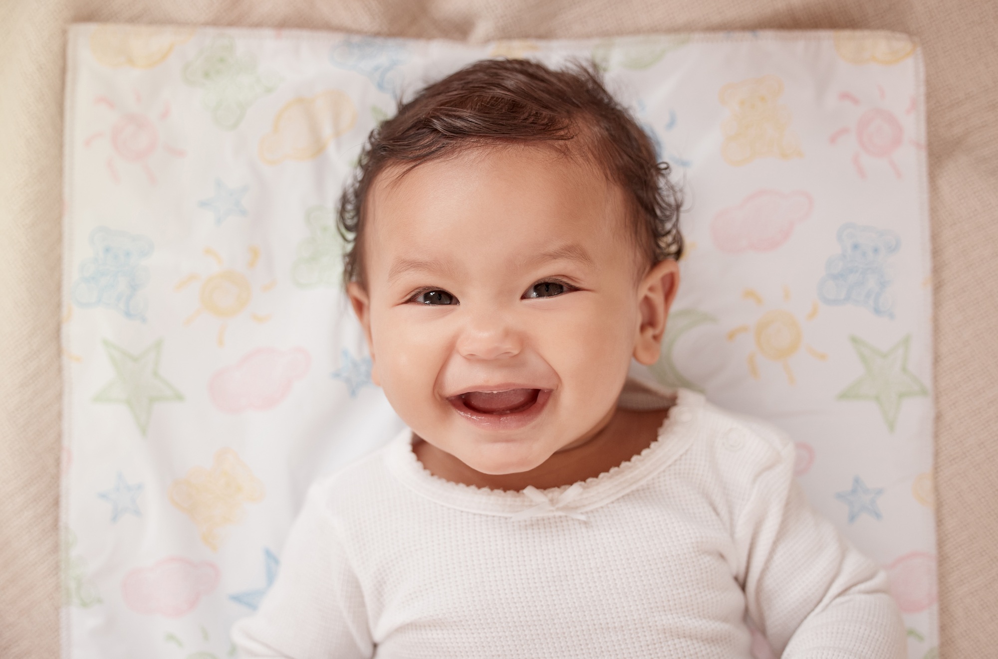 High angle portrait of an adorable baby girl lying on a diaper changing station at home