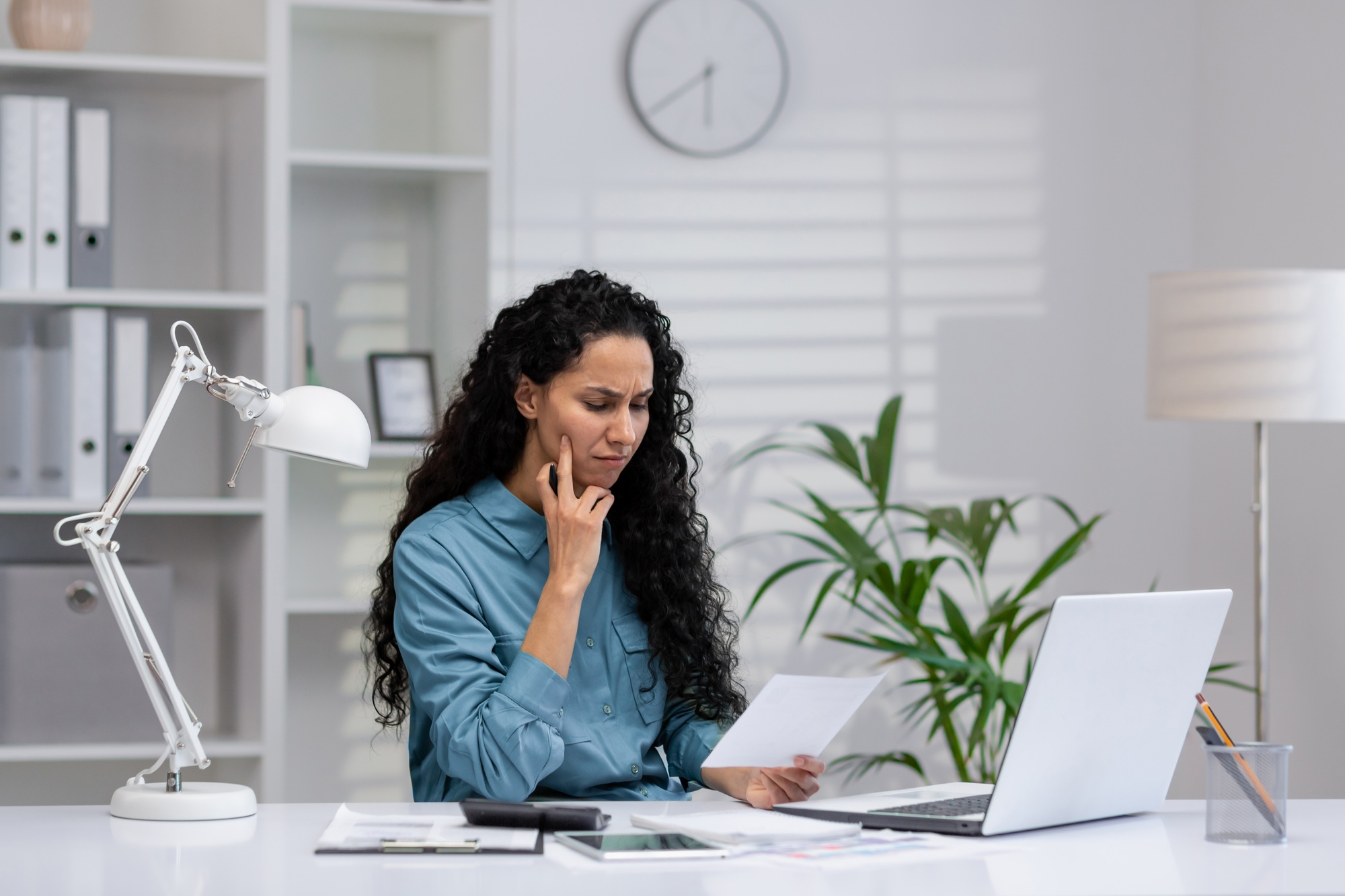 Hispanic businesswoman focusing on work in a home office setup