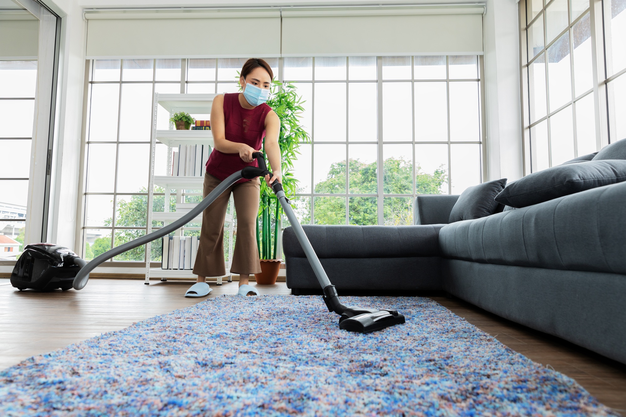 Housemaid using vacuum machine cleaning carpet