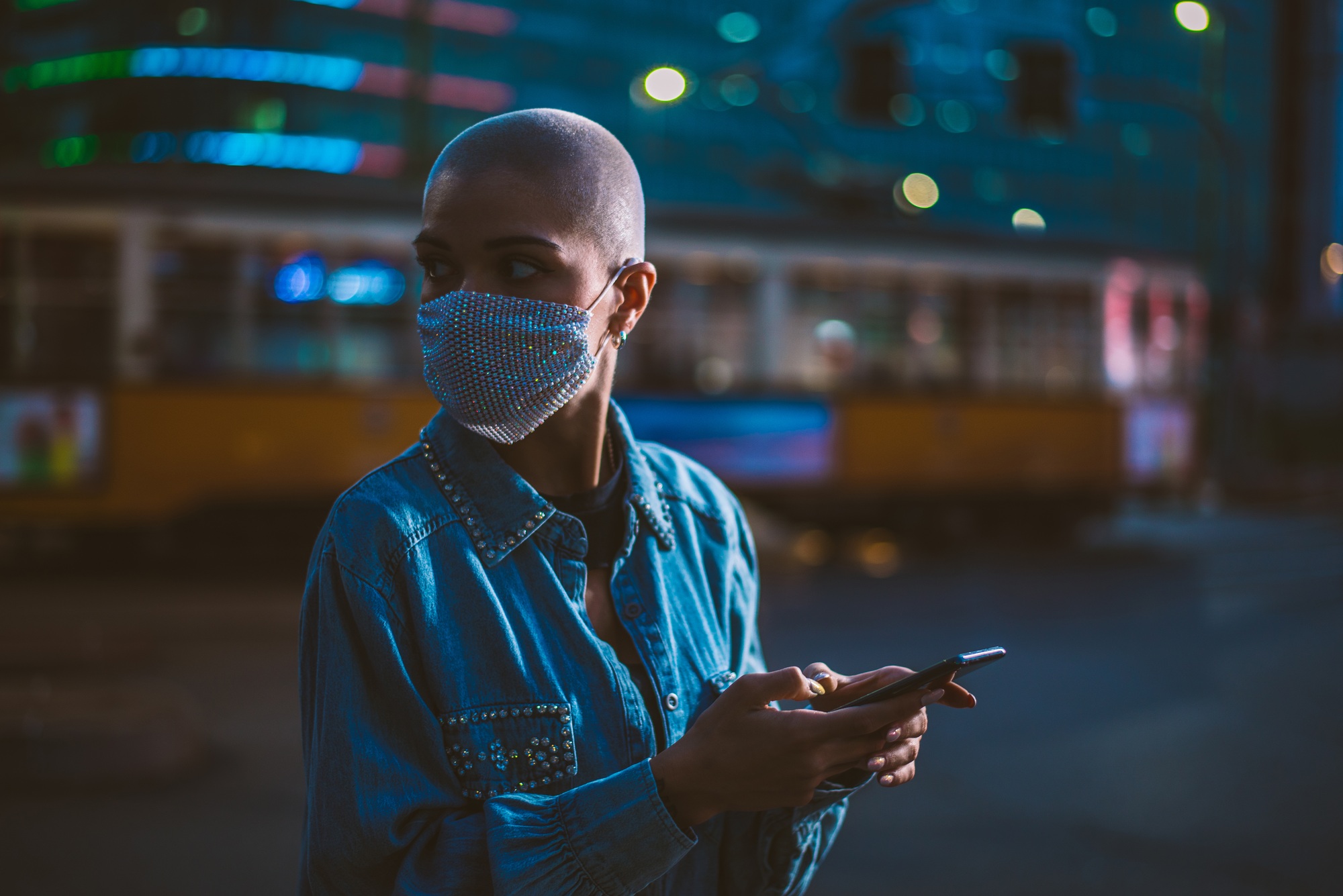 Image of a young woman using mobile phone on the street.