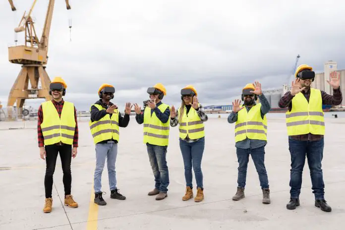 large group of coworkers shipping in container with virtual reality glasses - gamification concept