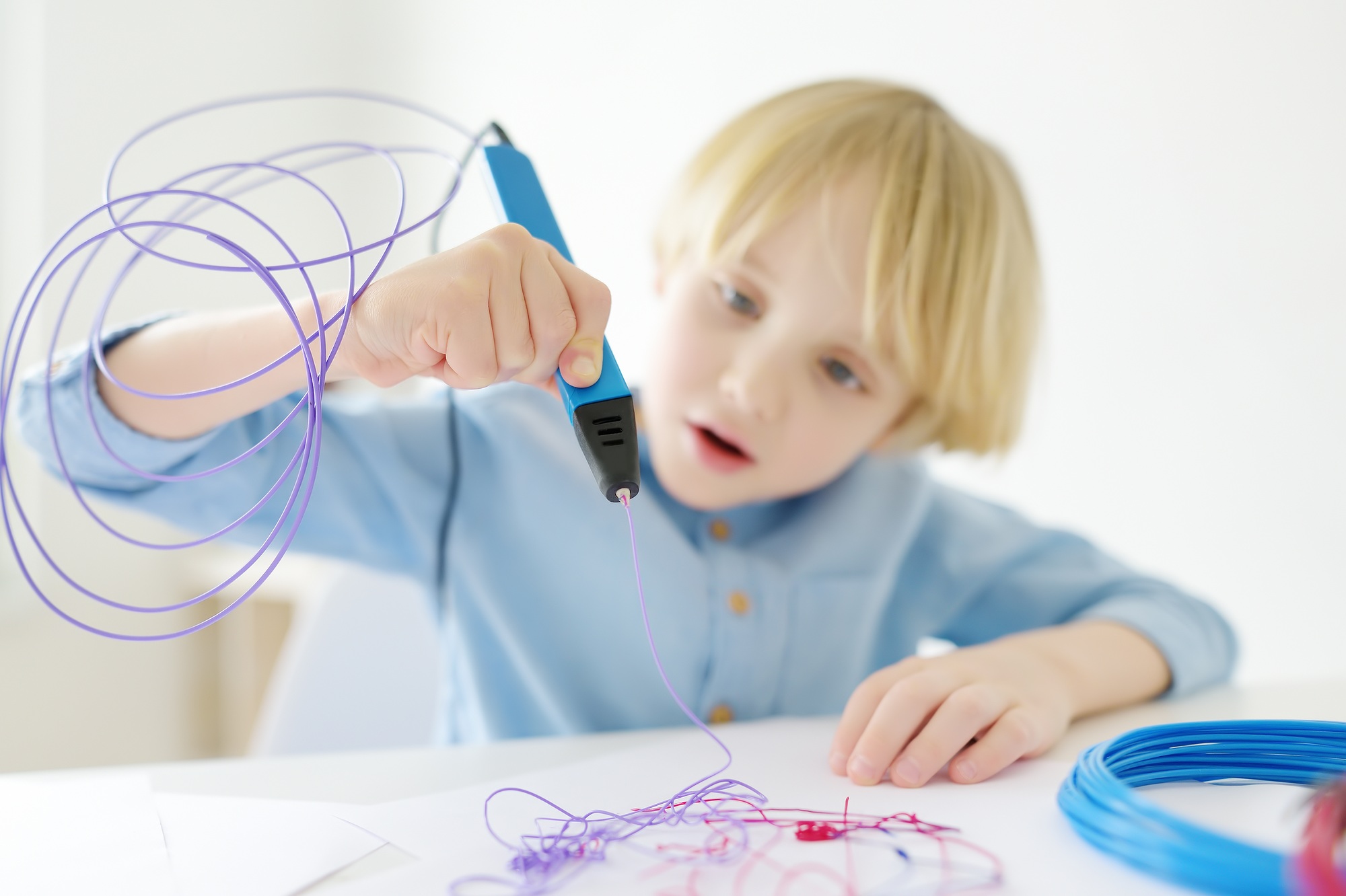 Little boy learning make model with 3d printing pen.  DIY.