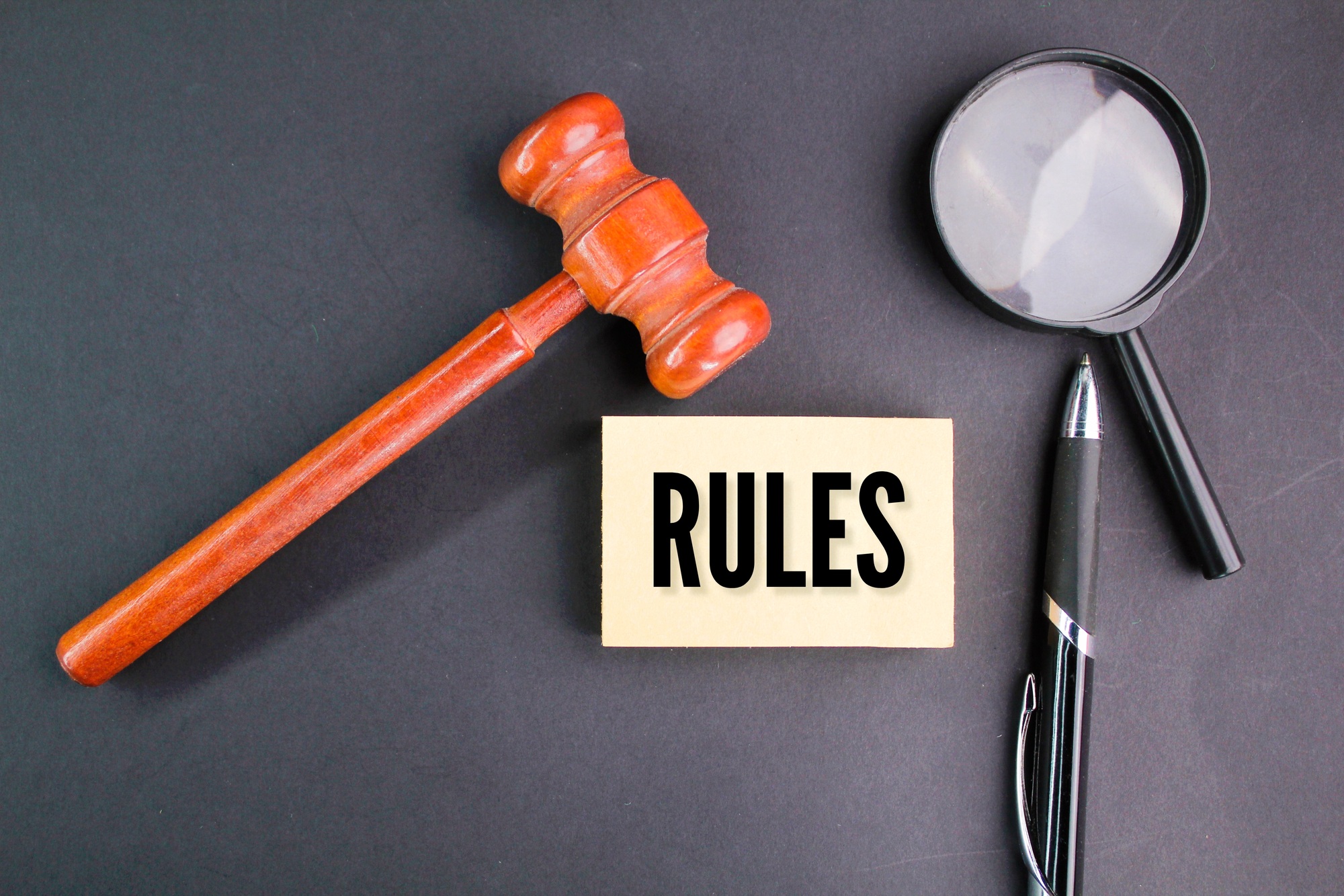 magnifying glass, pen and judge's gavel with the word RULES.
