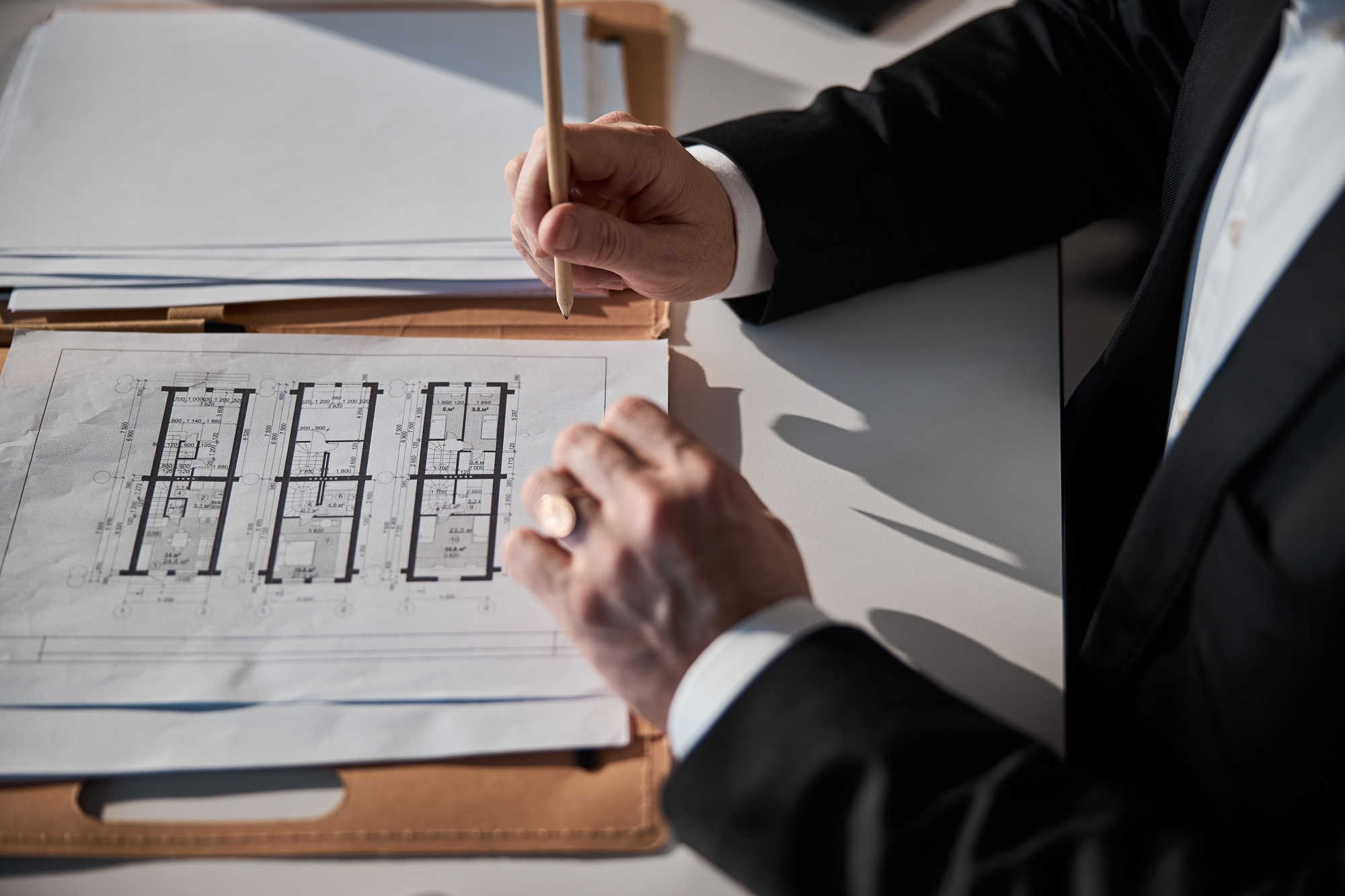 Male architect working on building plan in office