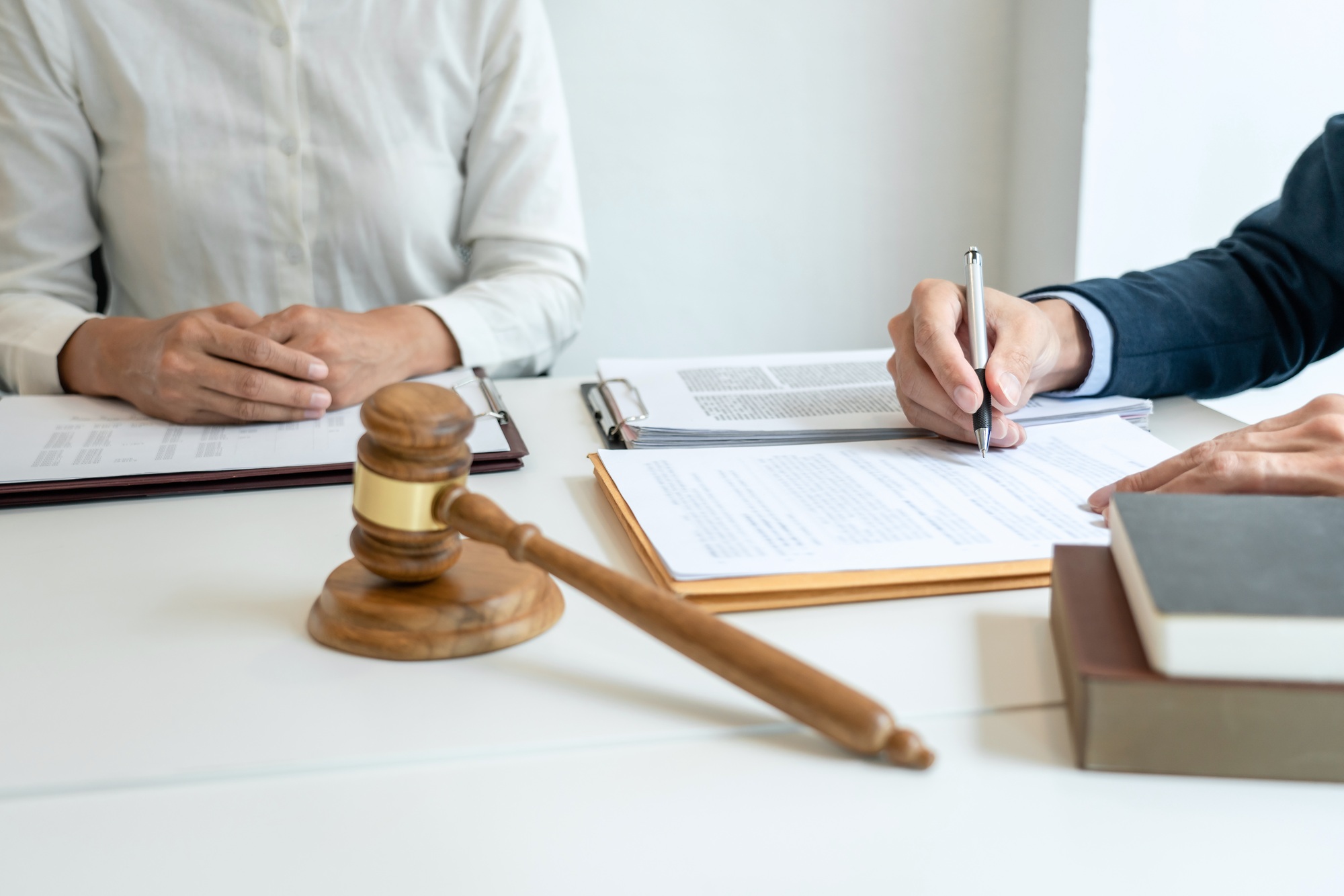 Male lawyer is pointing on legal document to explaining about consultation terms and condition